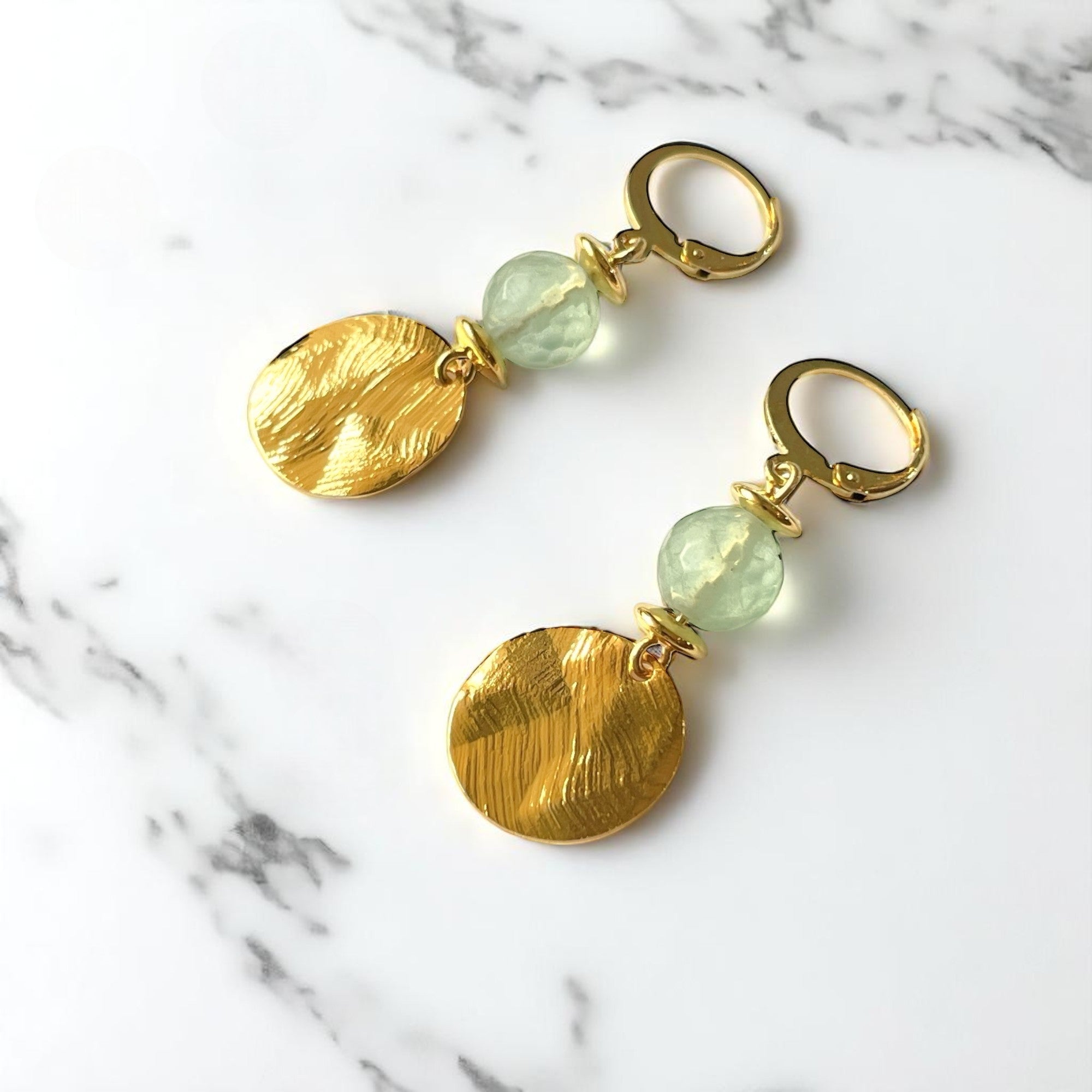 Petites boucles d'oreilles avec sequin rond en métal martelé doré à l'or fin et perles de Fluorite vert d'eau, sur marbre blanc