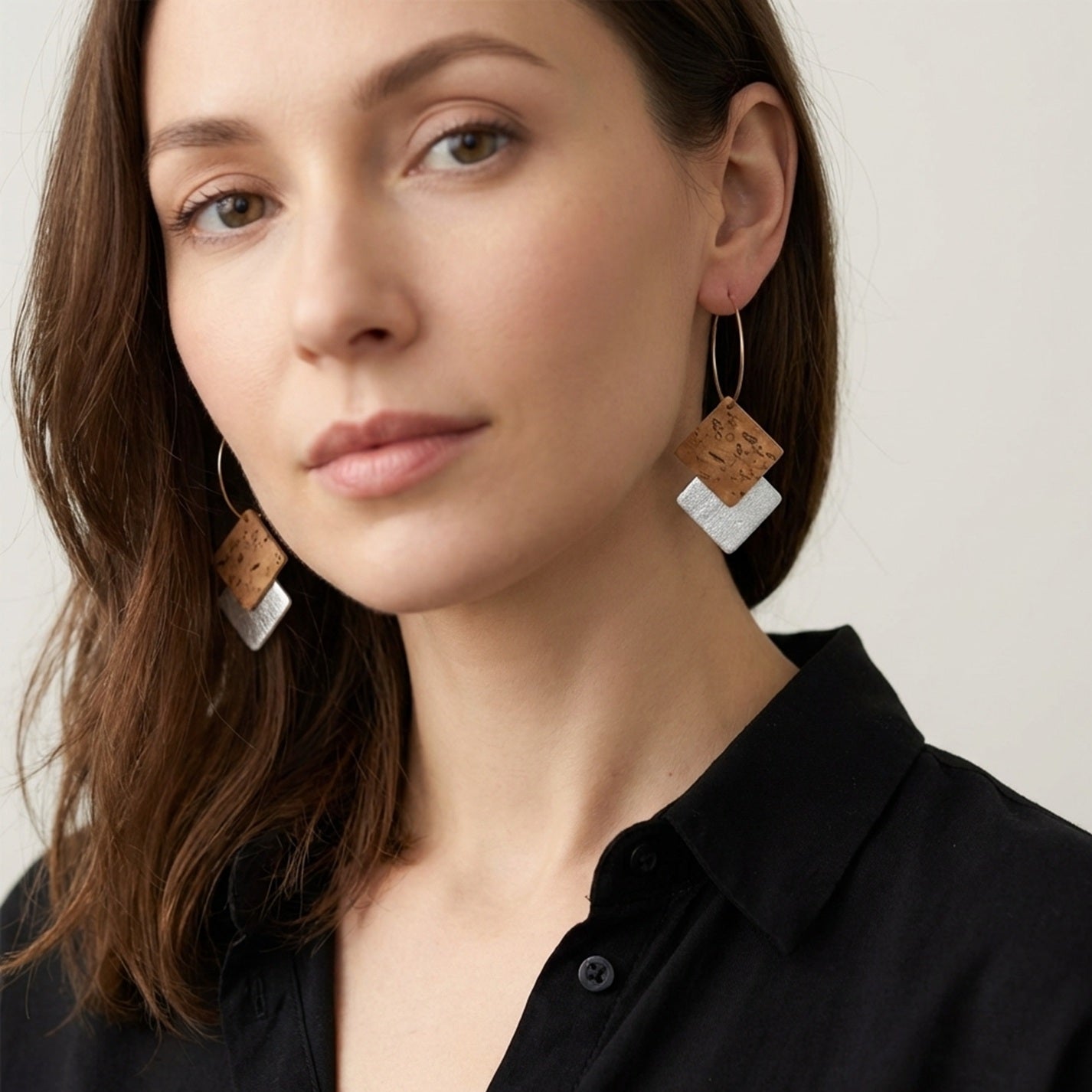 Boucles d'oreilles créoles dorées en liège brut et argenté. Forme géométrique double-losanges imbriqués, portées aux oreilles