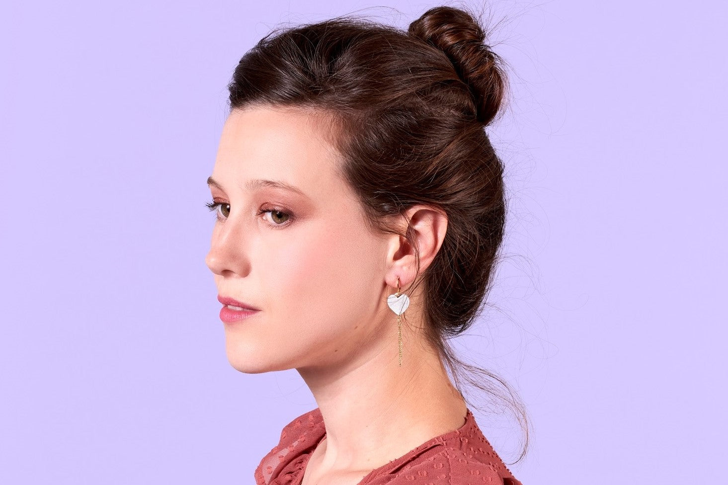 Jeune femme portant les boucles d'oreilles Daphné en formes de petits coeurs de cuir de la marque Nune