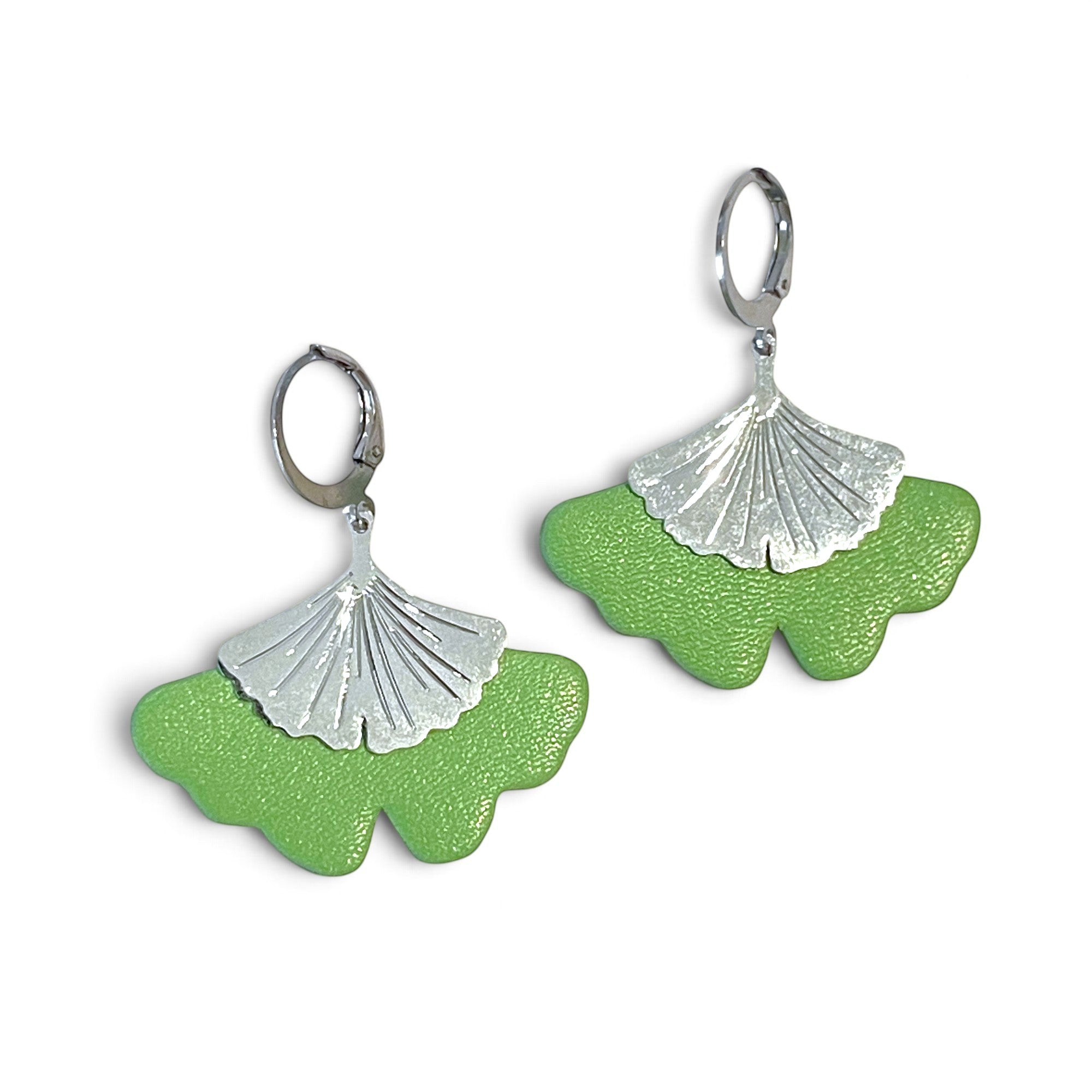 Boucles d'oreilles argentées pendantes en cuir vert pomme pastel en forme de gingko, sur fond blanc