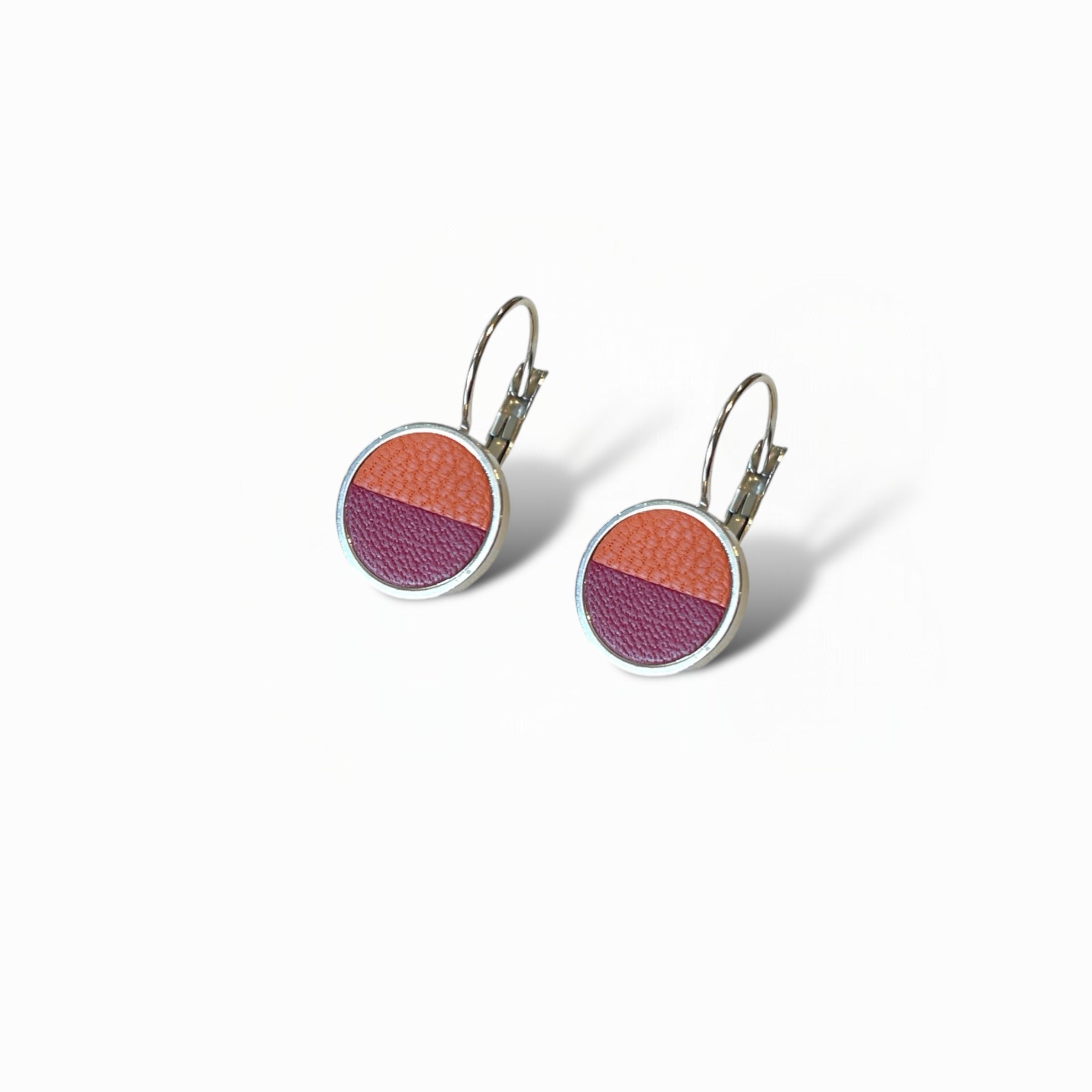 Petites boucles d'oreilles argentées pendantes rondes avec un duo de cuirs terracotta et pourpre en cabochon sur fond blanc