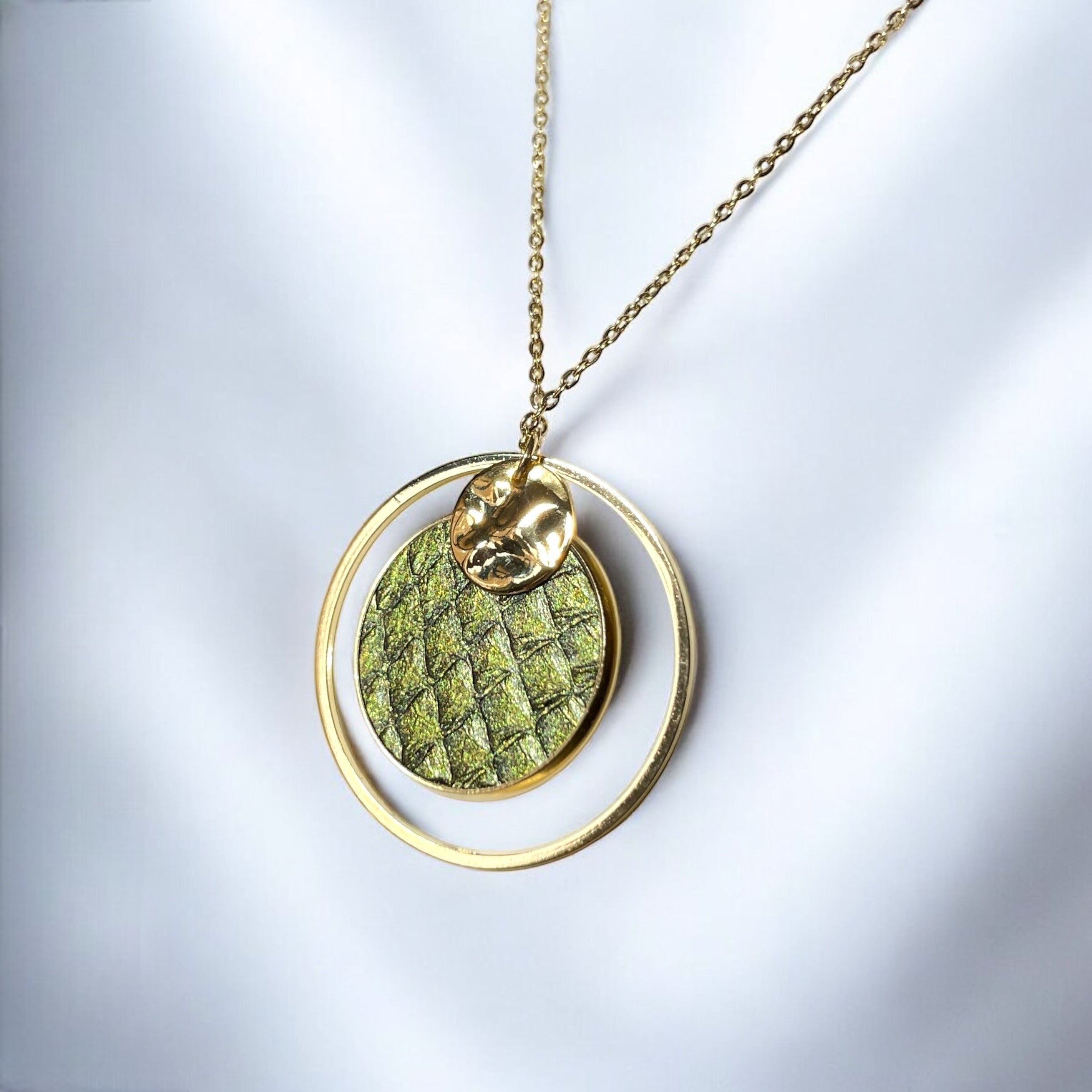 Fin collier doré avec pendentif rond en anneau avec une pièce de cuir marin kaki métallisé, sur fond argenté