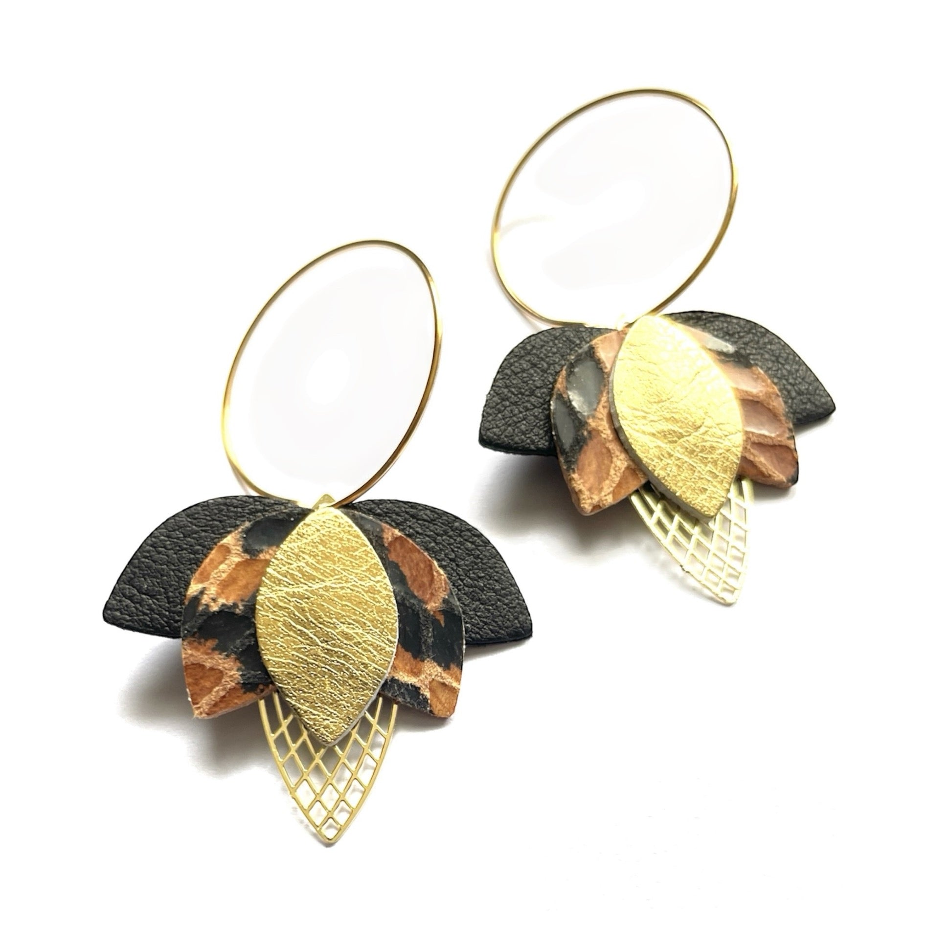 Créoles dorées en forme de fleurs de Lotus en cuirs noir, façon léopard et doré sur fond blanc