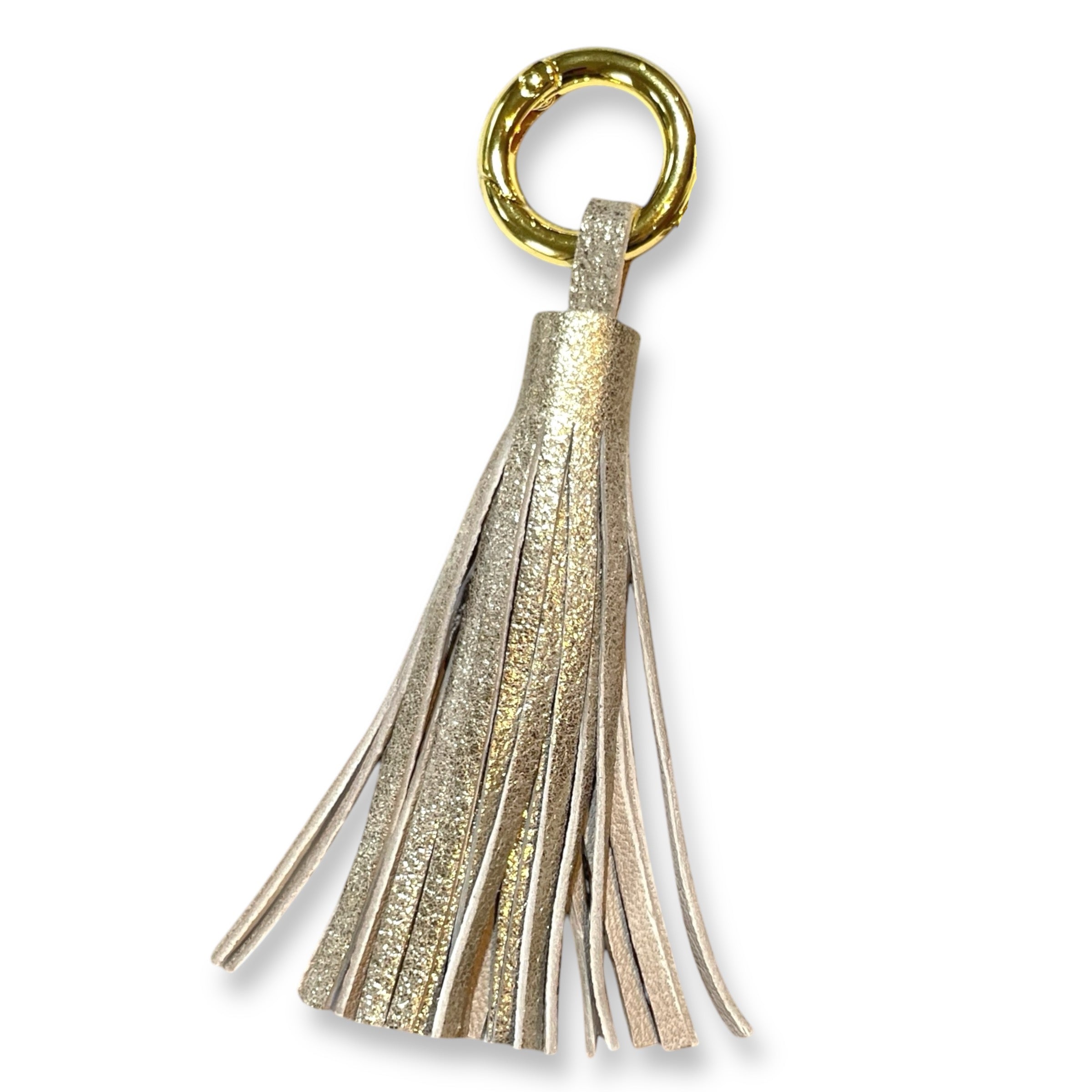 Bijou de sac doré portant un grand pompon en cuir doré vintage , sur fond blanc