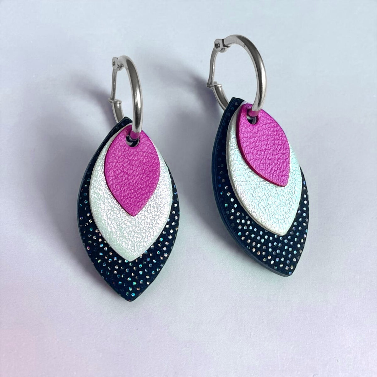 Créoles argentées avec pendentifs modulables en forme de feuilles en cuirs mauve satiné, blanc glacial irisé et noir à pois holographiques