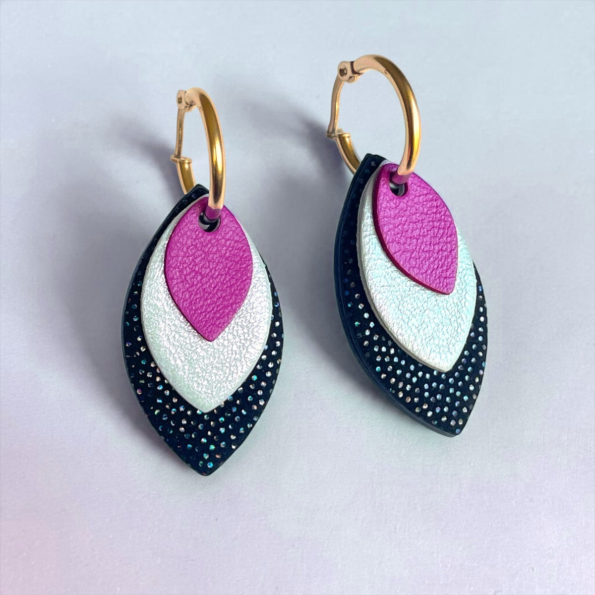 Créoles dorées avec pendentifs modulables en forme de feuilles en cuirs mauve satiné, blanc glacial irisé et noir à pois holographiques