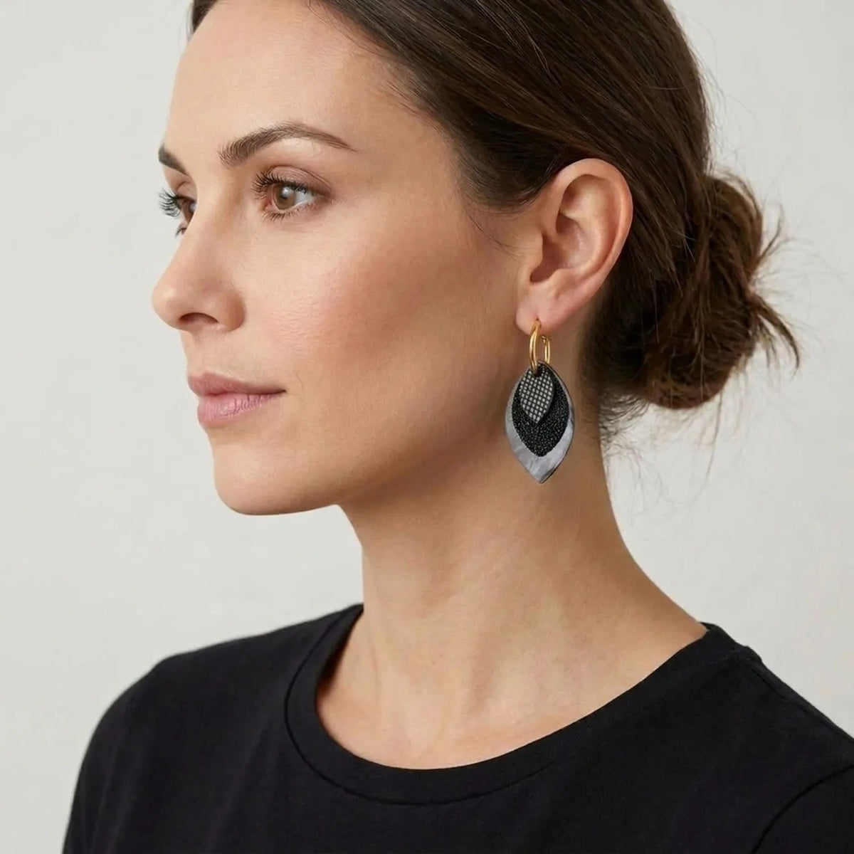 Créoles dorées avec pendentifs modulables en forme de feuilles en cuirs noir petit grain irisé, noir grainé pailleté et léopard noir vernis portees
