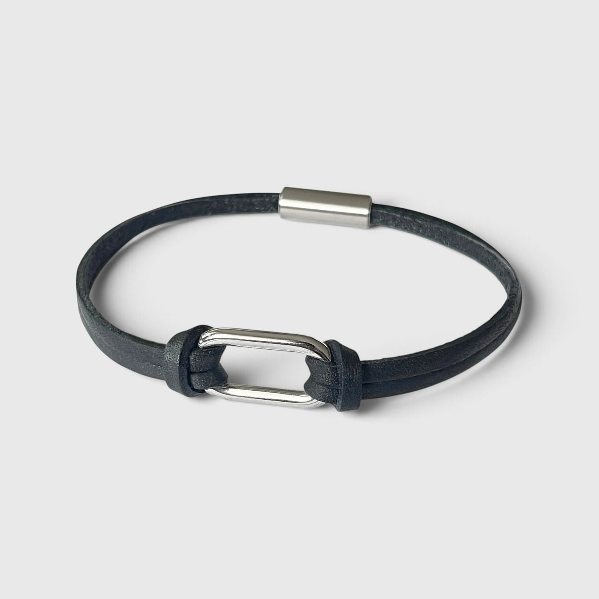 Bracelet homme à boucle argentée en fins liens de cuir noir avec fermoir aimanté argenté, vu à plat