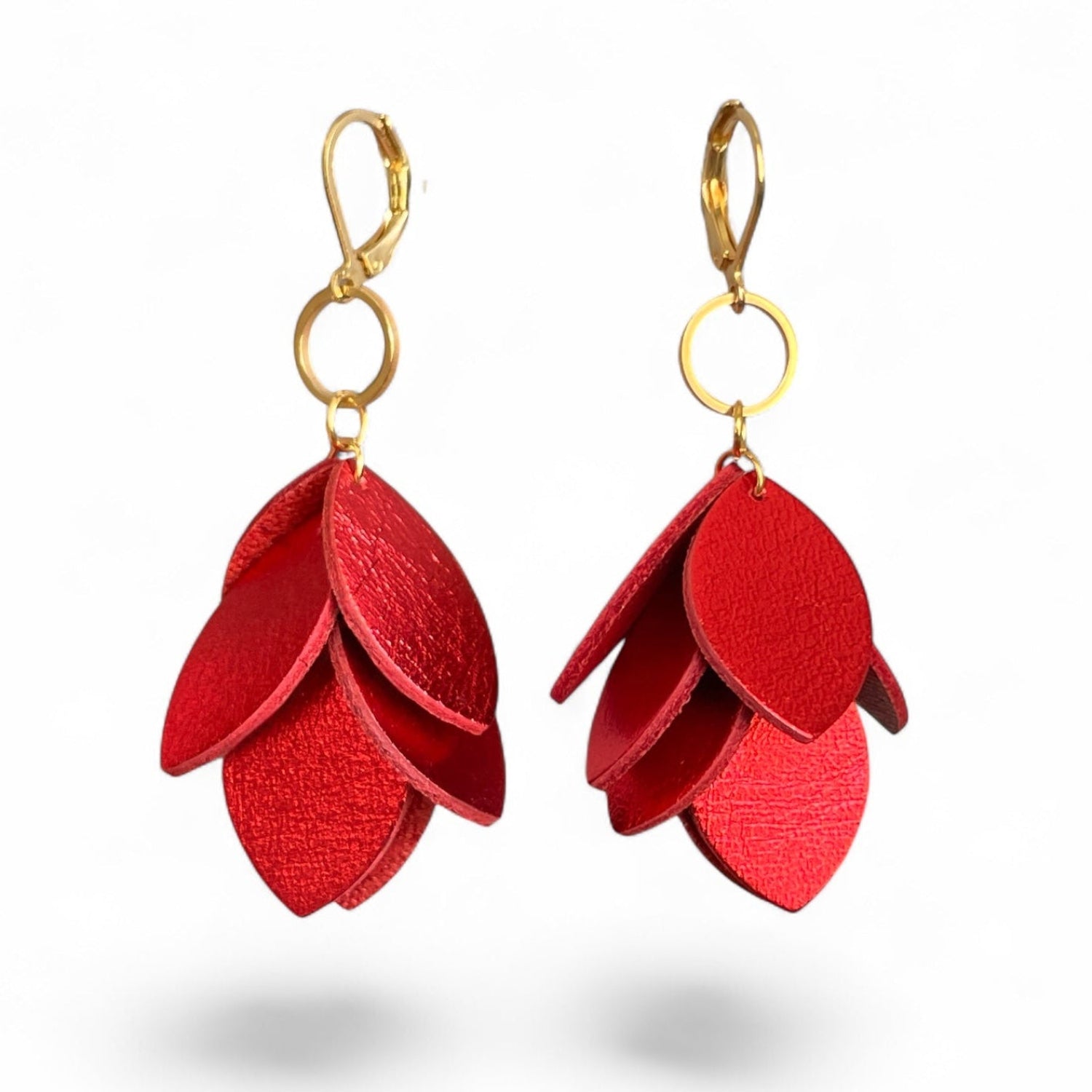 Boucles d’oreilles pendantes en cuir et acier inoxydable doré, de style bohème chic, avec pendentif en feuilles de cuir rouge métallisé superposées, sur fond blanc