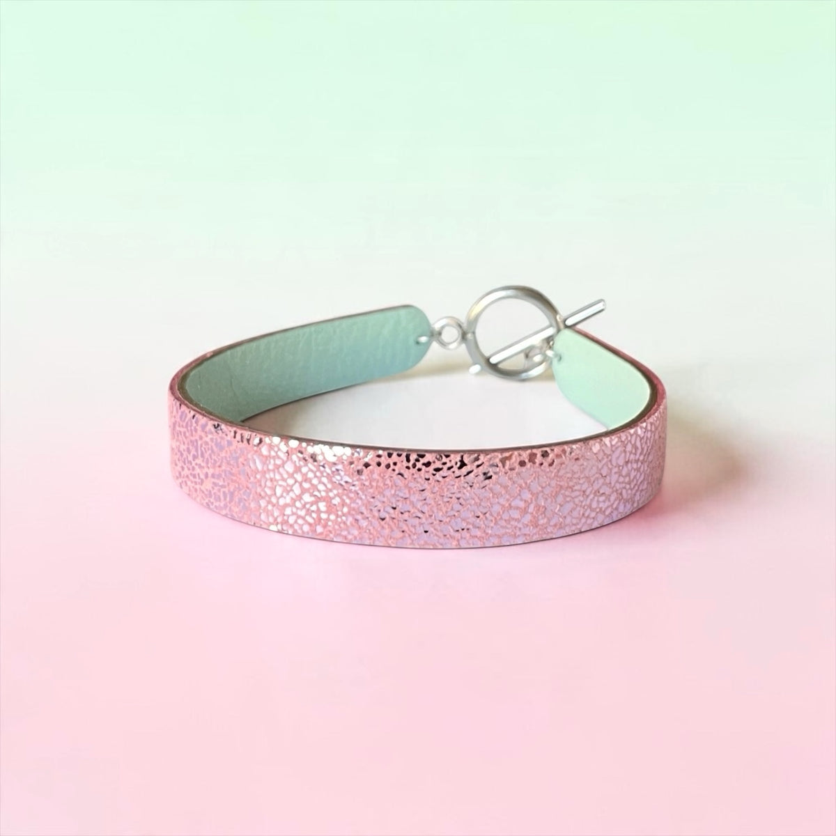 Bracelet femme en cuir double face bicolore, avec cuir rose brillant au recto et vert d'eau au verso avec fermoir boucle argentée en T