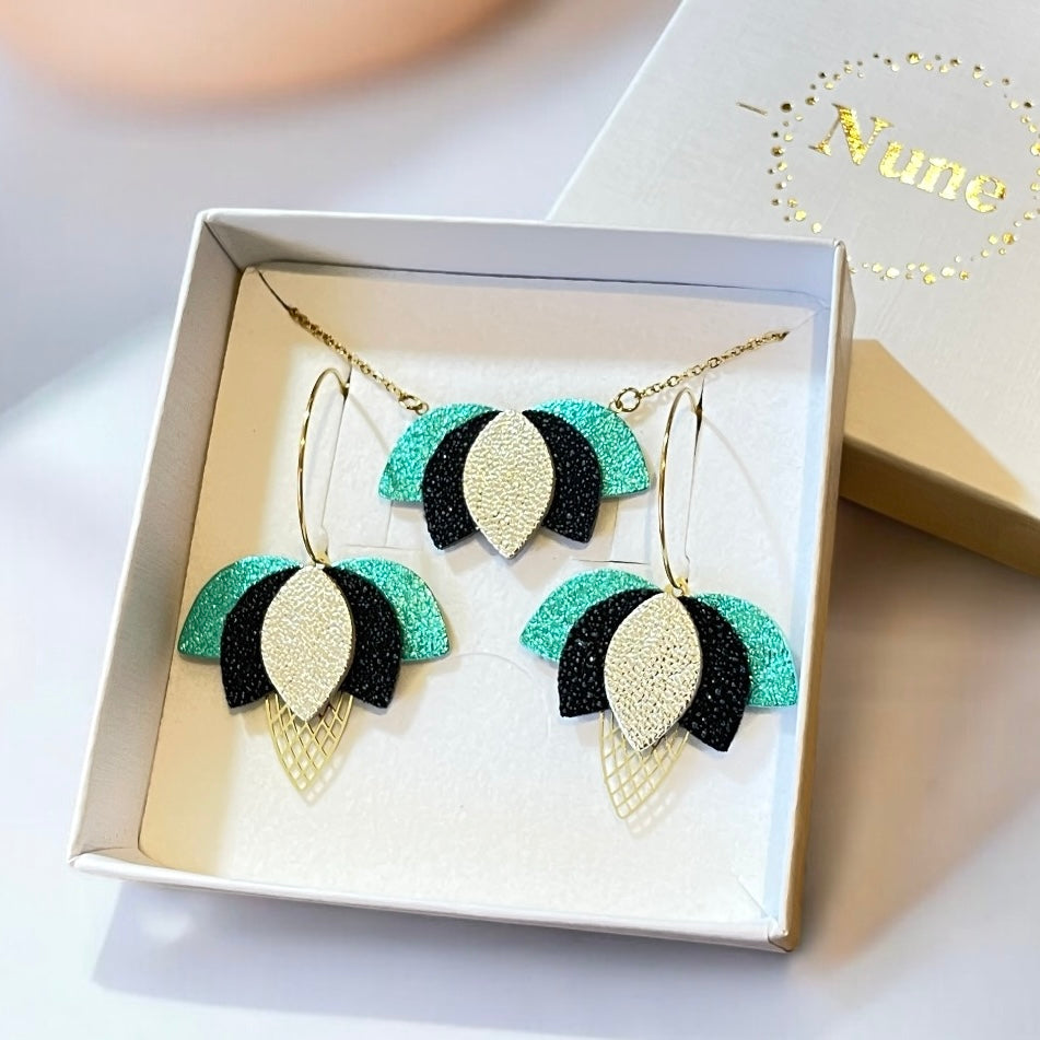 Parure collier et boucles d'oreilles Lotus en cuir de Nune, présentée dans un écrin blanc avec logo Nune, prêt à offrir