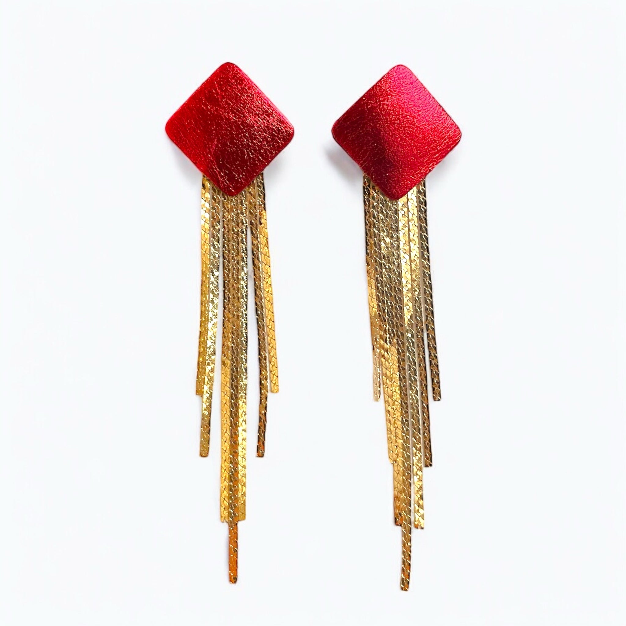 Puces d'oreilles losanges en cuir rouge métallisé avec leurs cascades de fines chaînettes dorées, sur fond blanc