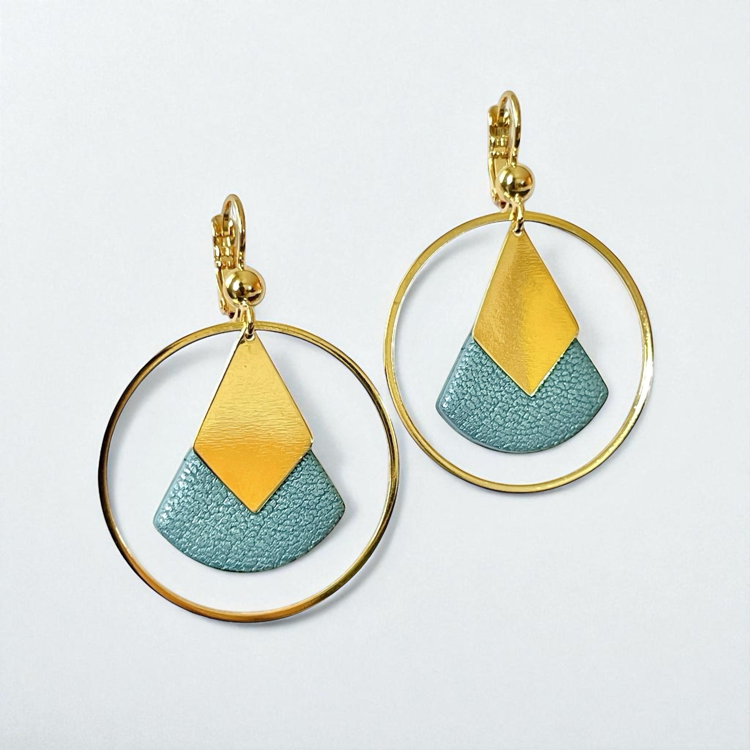 Boucles d'oreilles dorées à l'or fin Nune modèle Scala Créoles en cuir bleu gris nacré sur fond blanc