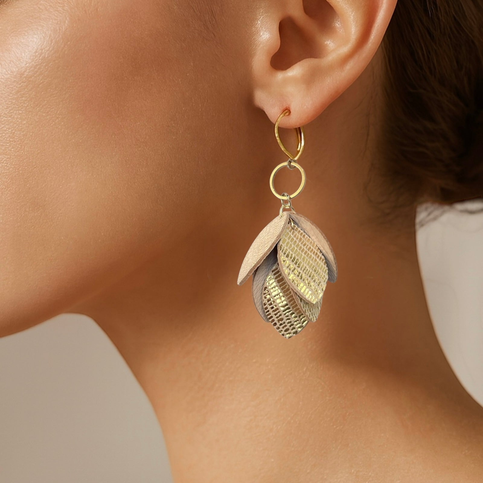 Boucles d’oreilles pendantes en cuir et acier inoxydable doré, de style bohème chic, avec pendentif en feuilles de cuir doré façon serpent superposées, portées à l'oreille