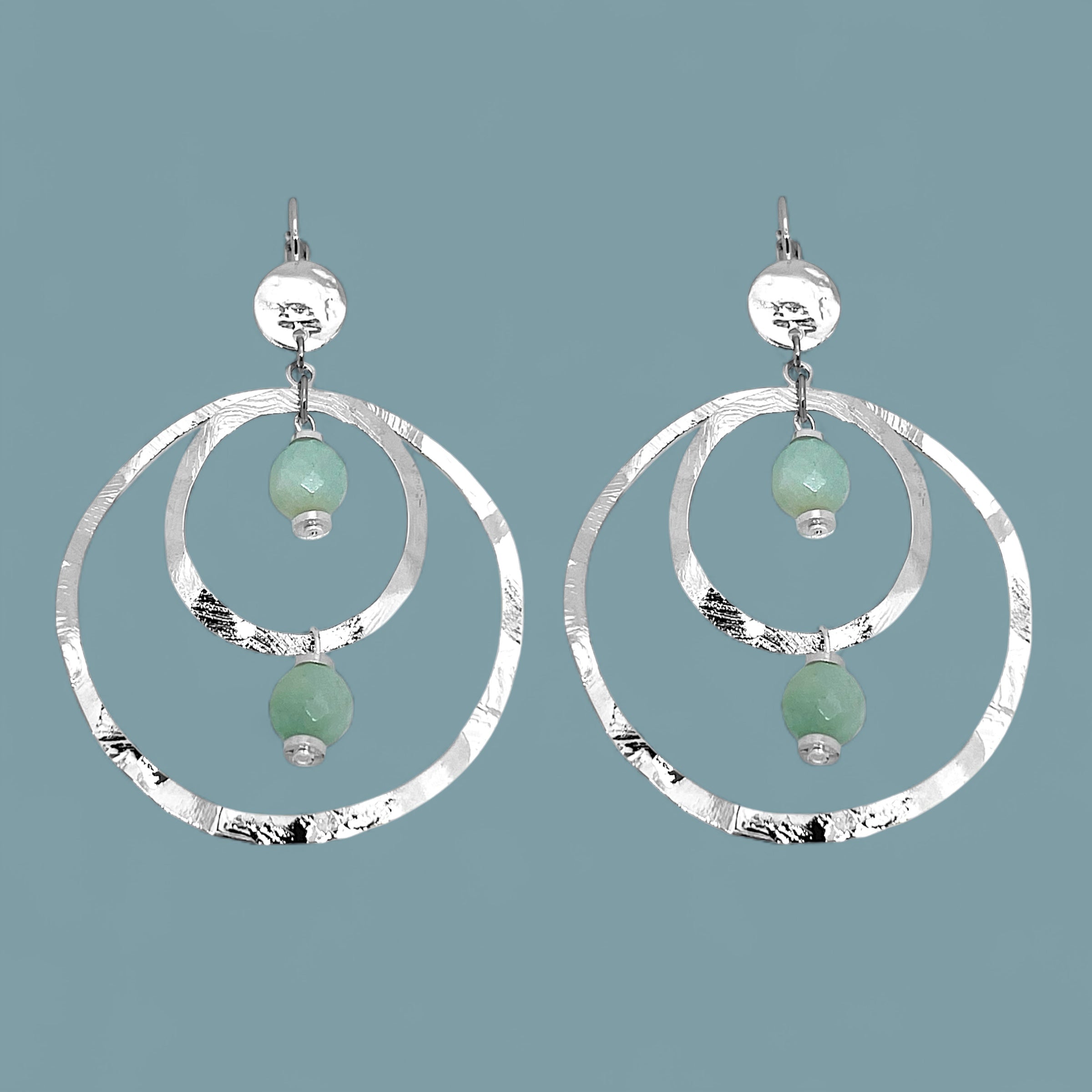 Grandes boucles d'oreilles créoles en métal martelé argenté et perles minérales naturelles d'amazonite, de forme ronde, avec doubles anneaux, sur fond bleu gris