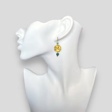 Charger l&#39;image dans la galerie, Boucles d&#39;oreilles pendantes de forme ronde avec 2 demi-lunes, en métal martelé doré à l&#39;or fin et perles d&#39;amazonite et d&#39;apatite bleue, portées à l&#39;oreille sur un buste blanc
