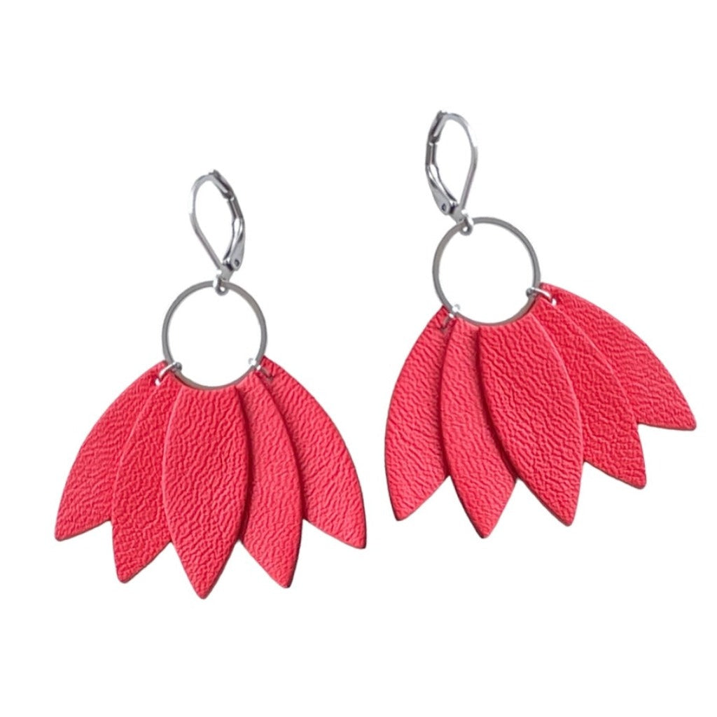 Grandes boucles d'oreilles argentées n forme de couronne de plumes en cuir rose saumon, sur fond blanc