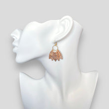 Charger l&#39;image dans la galerie, Grande boucle d&#39;oreille dorée en forme de couronne de plumes en cuir or rosé froissé, portée à l&#39;oreille
