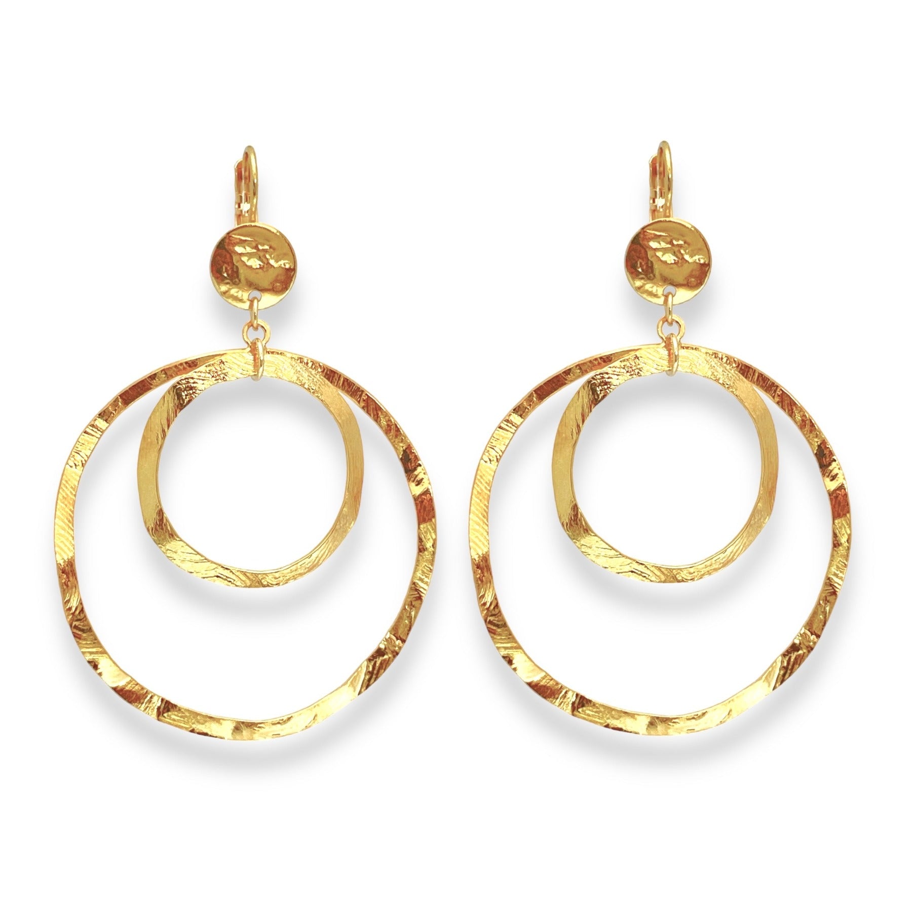 Grandes boucles d'oreilles créoles dorées à double anneau en métal martelé, avec attaches-dormeuses, sur fond blanc