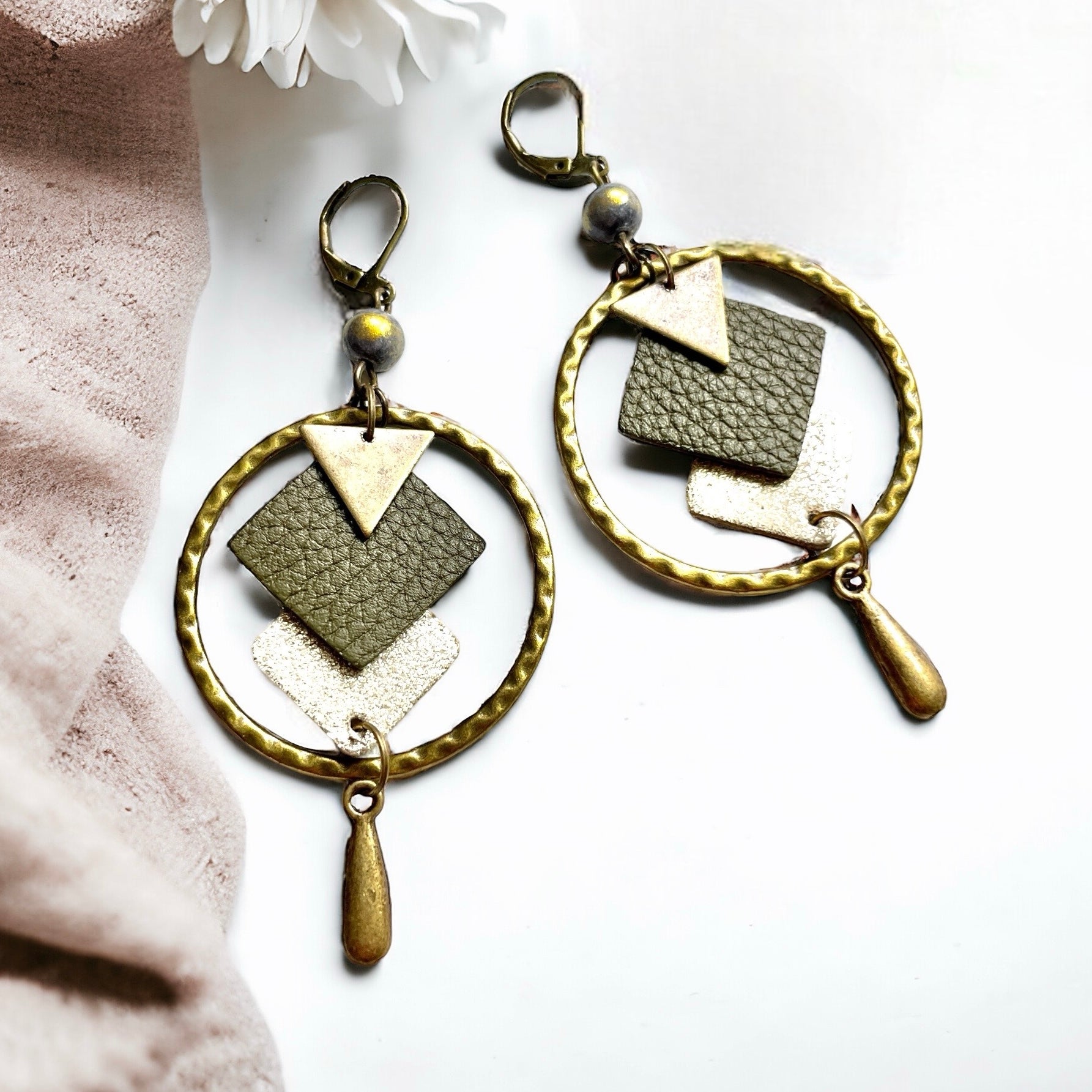 Boucles d'oreilles en bronze Nune modèle Adamante Créoles en cuir kaki grainé e forme de losange sur fond blanc