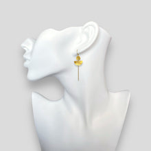 Charger l&#39;image dans la galerie, Longues boucles d&#39;oreilles dorées pendantes en forme de demi-lunes, allongées par une chaînette, portées aux oreilles sur un buste blanc
