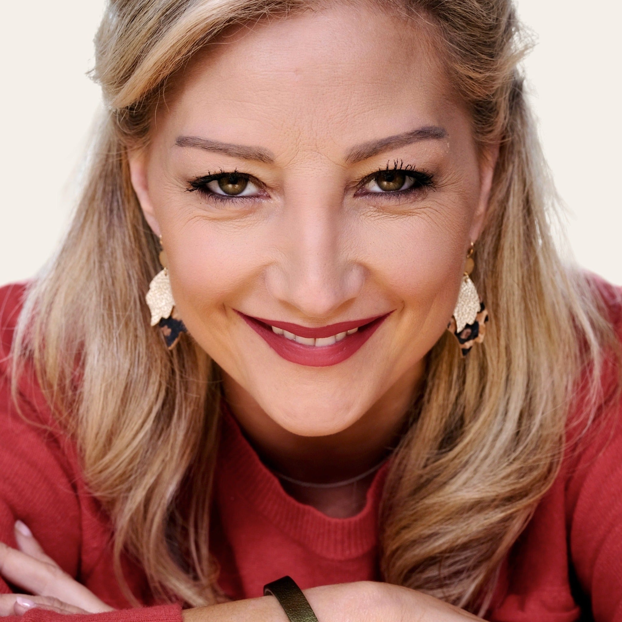 Femme blonde portant les paire de Boucles d'oreilles style bohème-chic, dorées à l'or fin, en forme de flammes en cuirs recyclés doré antique mat et façon léopard