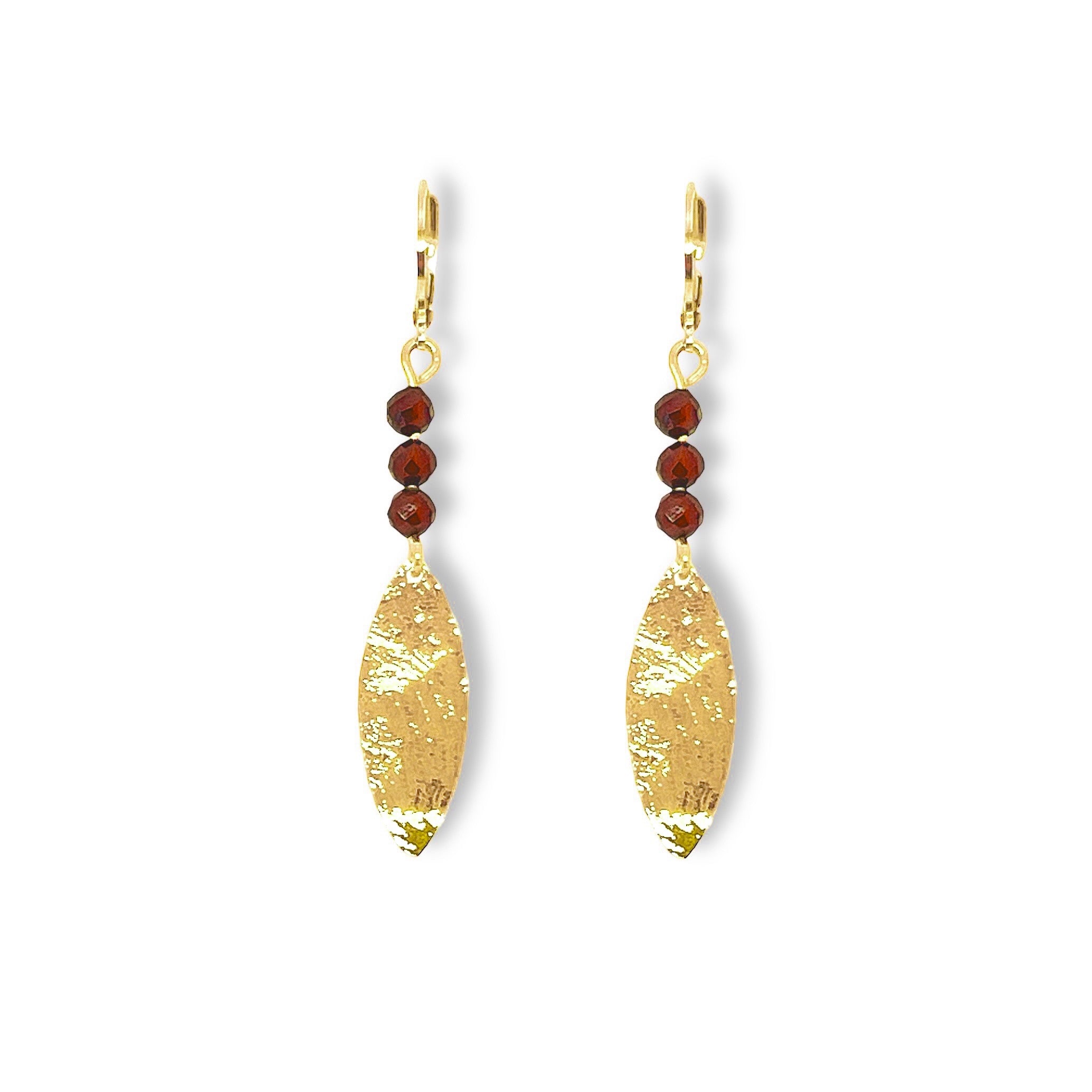 Boucles d'oreilles fines en pointe en métal martelé doré à l'or fin et petites perles de grenat, sur fond blanc