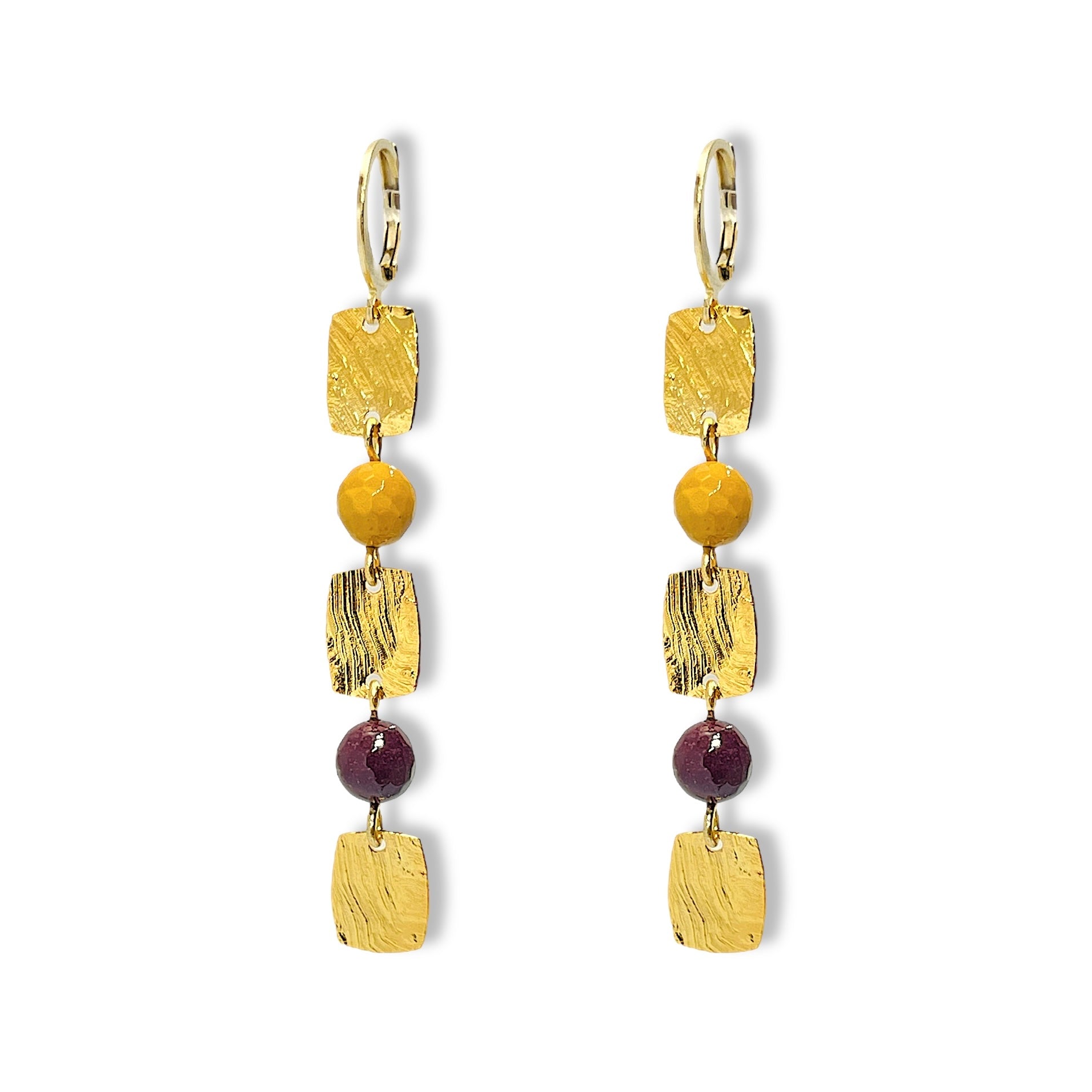 Fines boucles d'oreilles pendantes en chapelet de petits sequins rectangulaires en métal martelé doré à l'or fin et perles de mokaite ocre et lie de vin, sur fond blanc