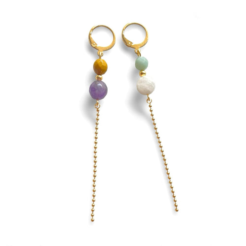 Fines boucles d'oreilles pendantes dorées en perles de pierres naturelles colorées et chaînette sur fond blanc
