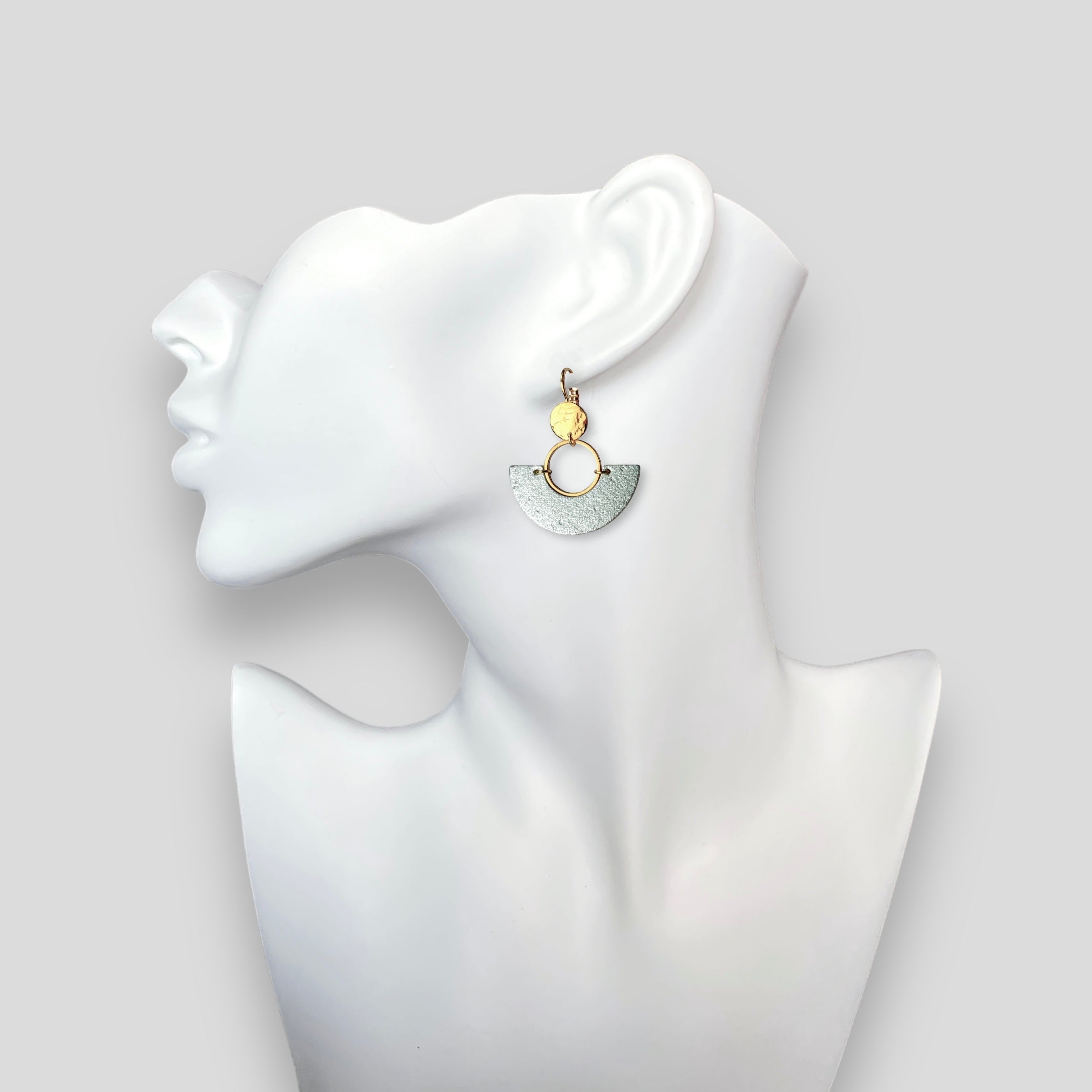 boucle d'oreille dorée en forme de demi-lune en liège argenté, portée à l'oreille