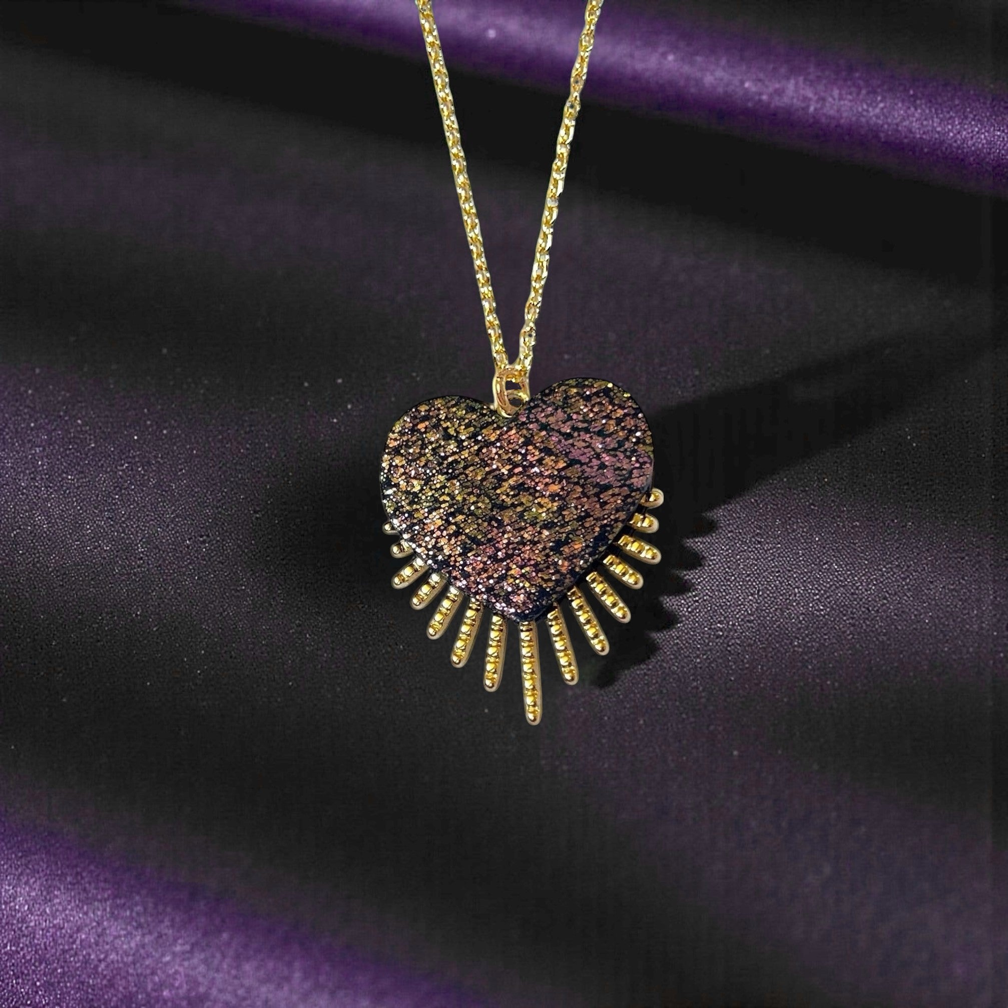 NUNE collier doré Vénus en forme de cœur style ex-voto en cuir noir pailleté irisé recyclé, sur fond noir