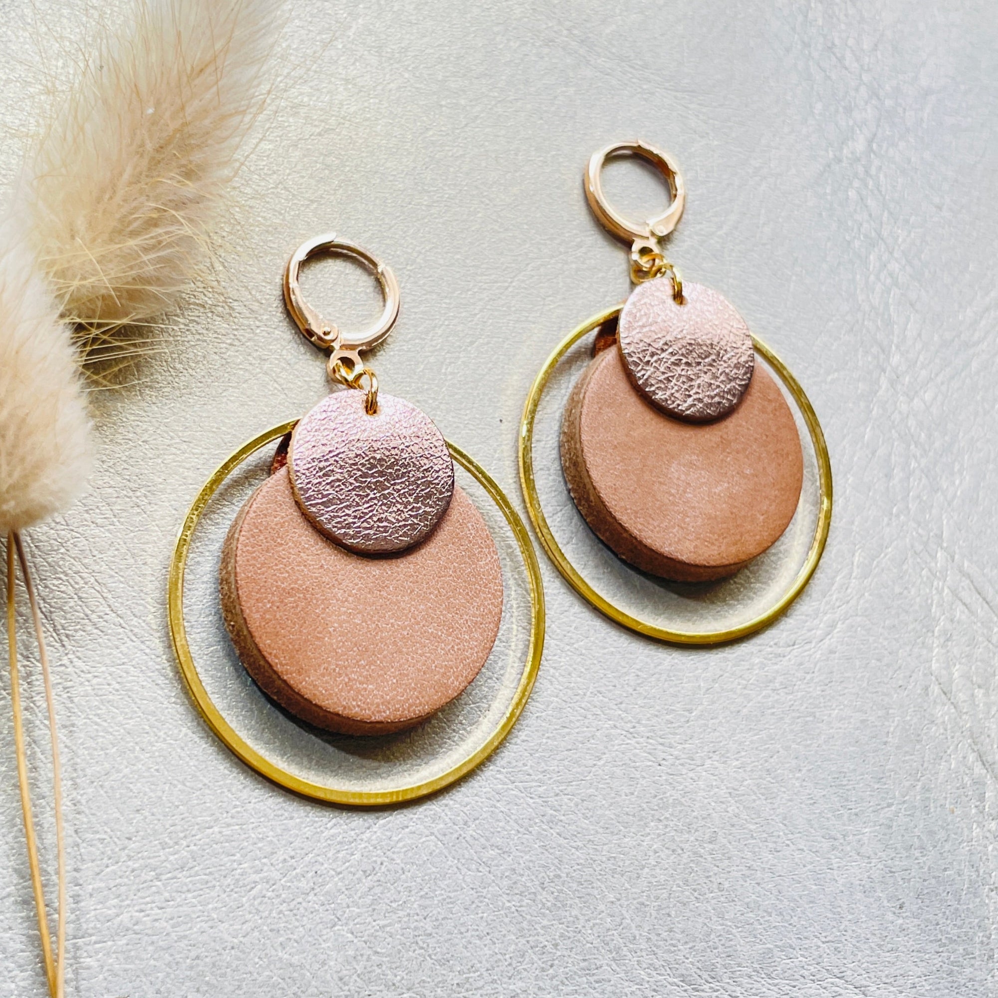 boucles d'oreilles dorées Nune modèle Danaé en cuirs beige amande et cannelle dorée satinée sur fond gris doré