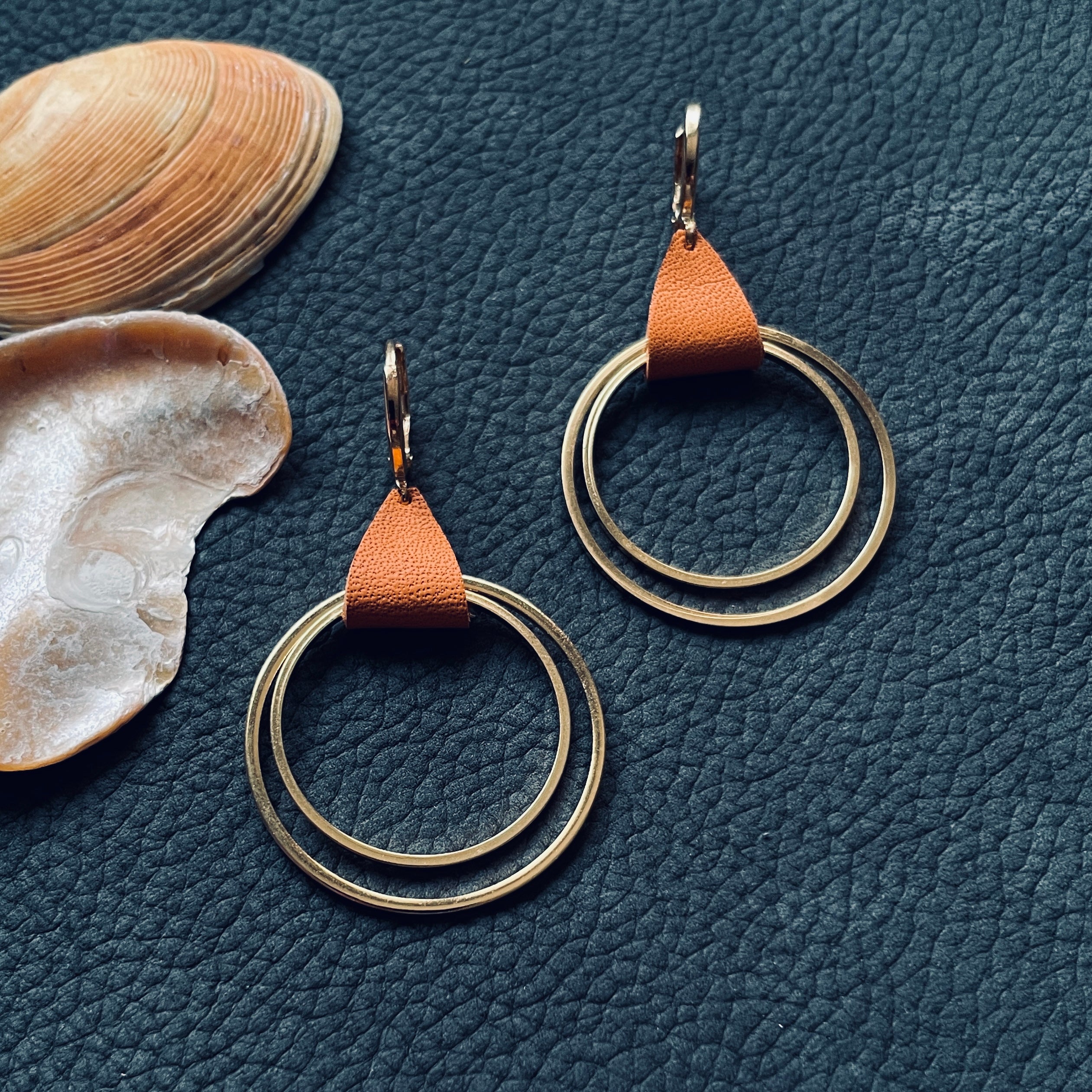 Créoles dorées modèle Vega de la marque Nune, avec une touche de cuir camel