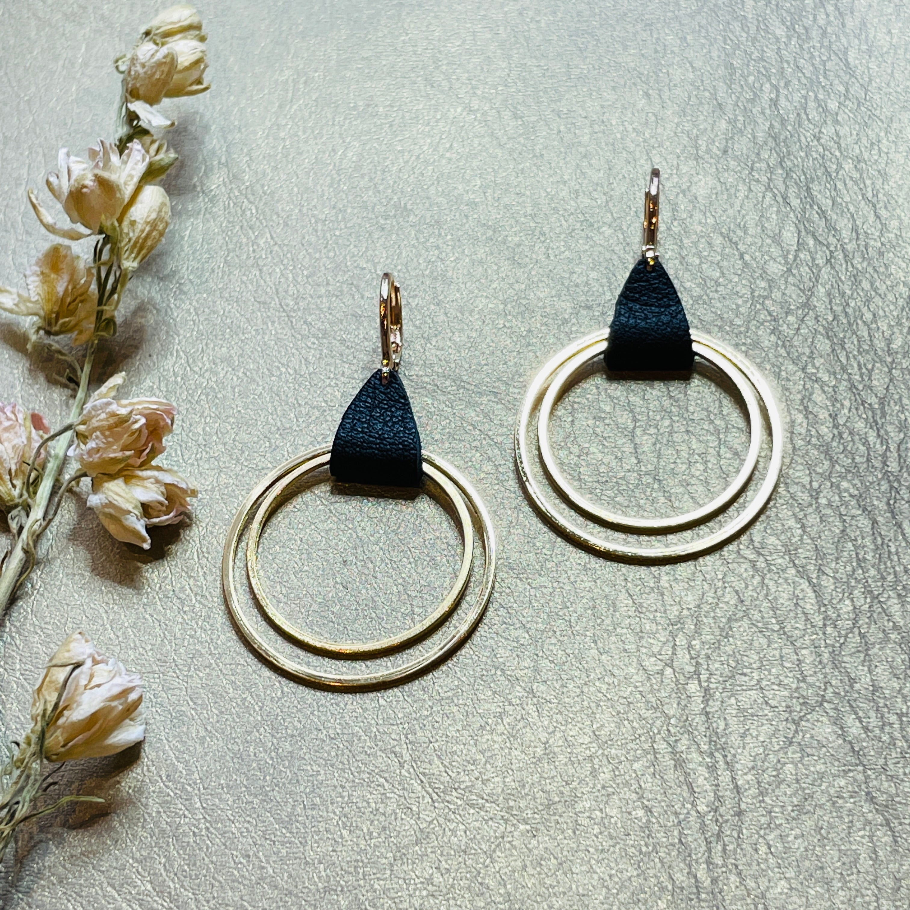 Créoles dorées modèle Vega de la marque Nune, avec une touche de cuir noir