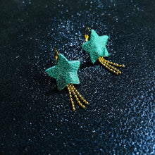 Charger l&#39;image dans la galerie, boucles d&#39;oreilles dorées Nune modèle Stella en forme d&#39;étoiles, en cuir vert émeraude brillant intense, sur fond noir paillettes

