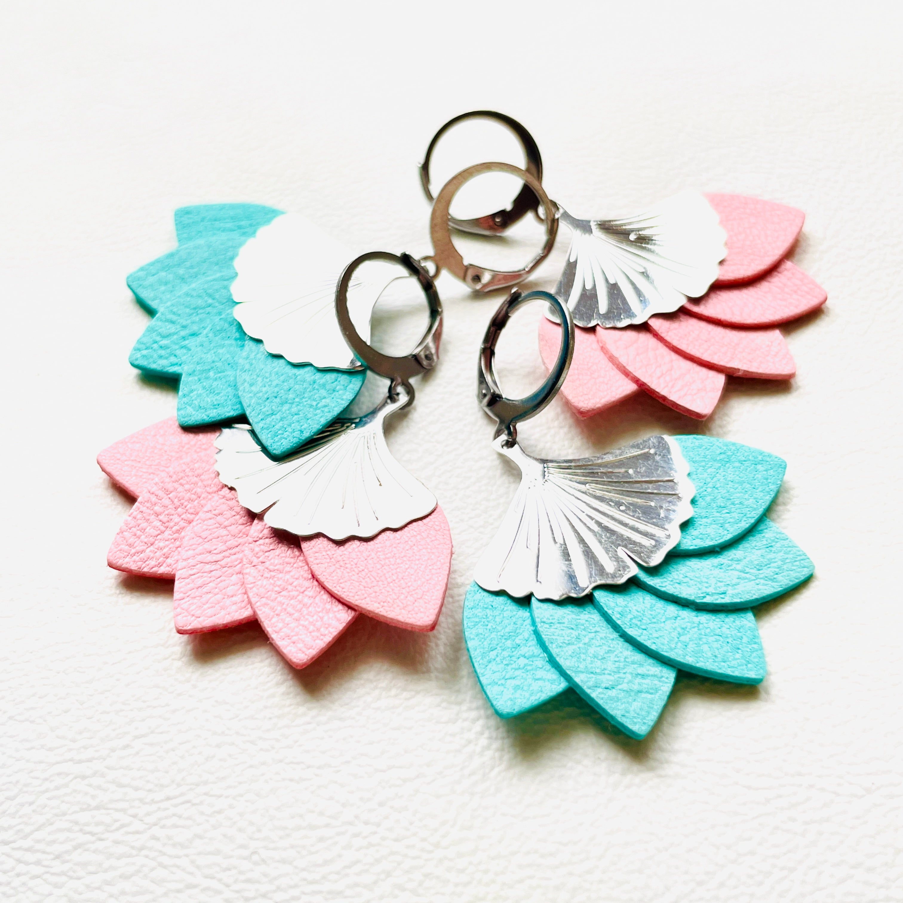 Boucles d'oreilles argentées Nune modèle Ginka en pétales de cuirs rose pastel et menthe, sur fond blanc