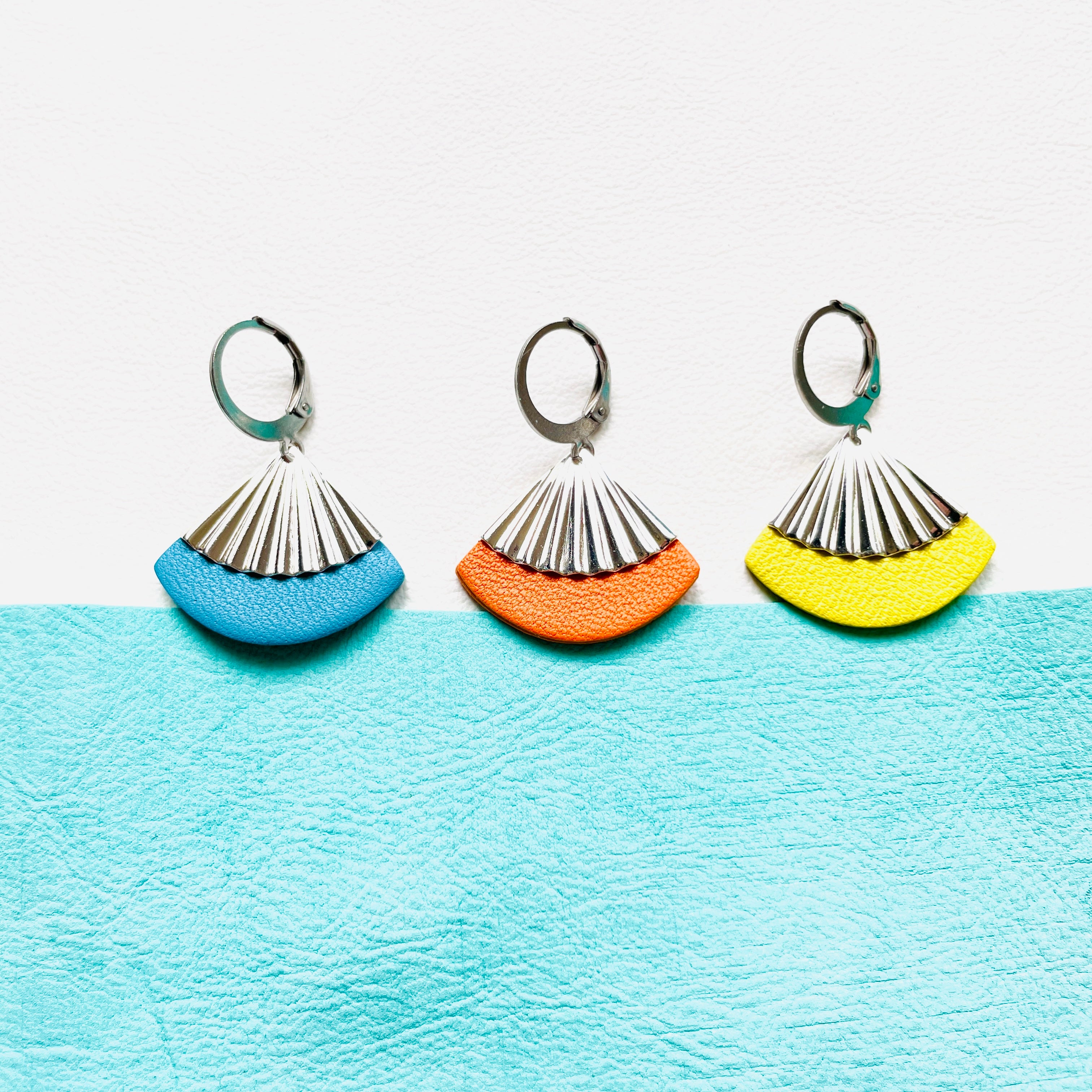 Petites boucles d'oreilles argentées Nune modèle Alya en forme d'éventail en cuirs bleu ciel, orange et jaune citron, sur fond cuir blanc et menthe