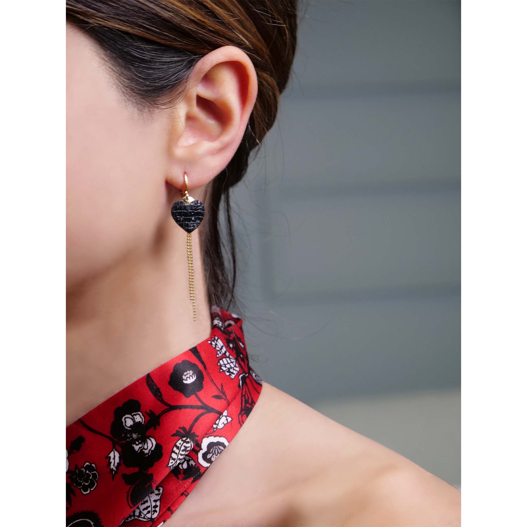 fines boucles d'oreilles dorées cœur cuir noir brillant serpent