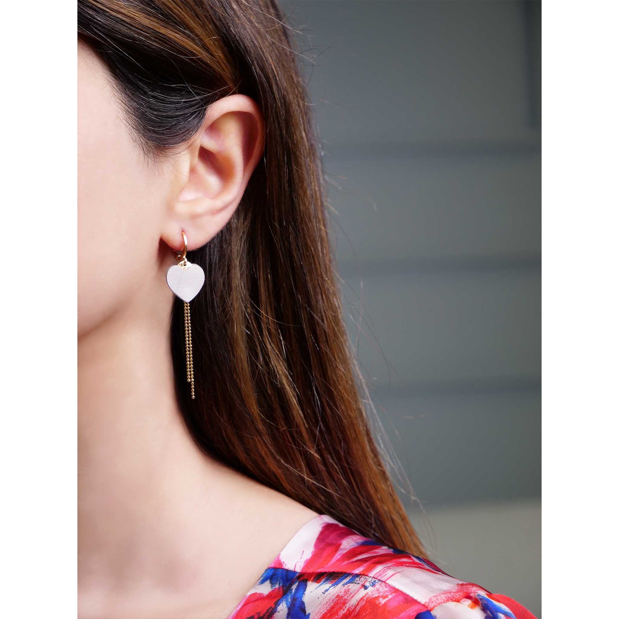 fines boucles d'oreilles dorées cœur cuir blanc cassé nacré portées à l'oreille