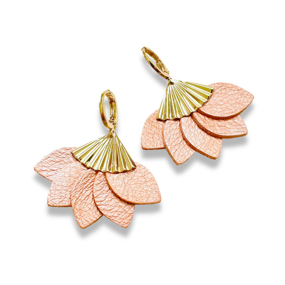 boucles d'oreilles dorées en forme éventail en cuir recyclé corail nacré clair de la marque Nune modèle Sakura, sur fond de cuir blanc