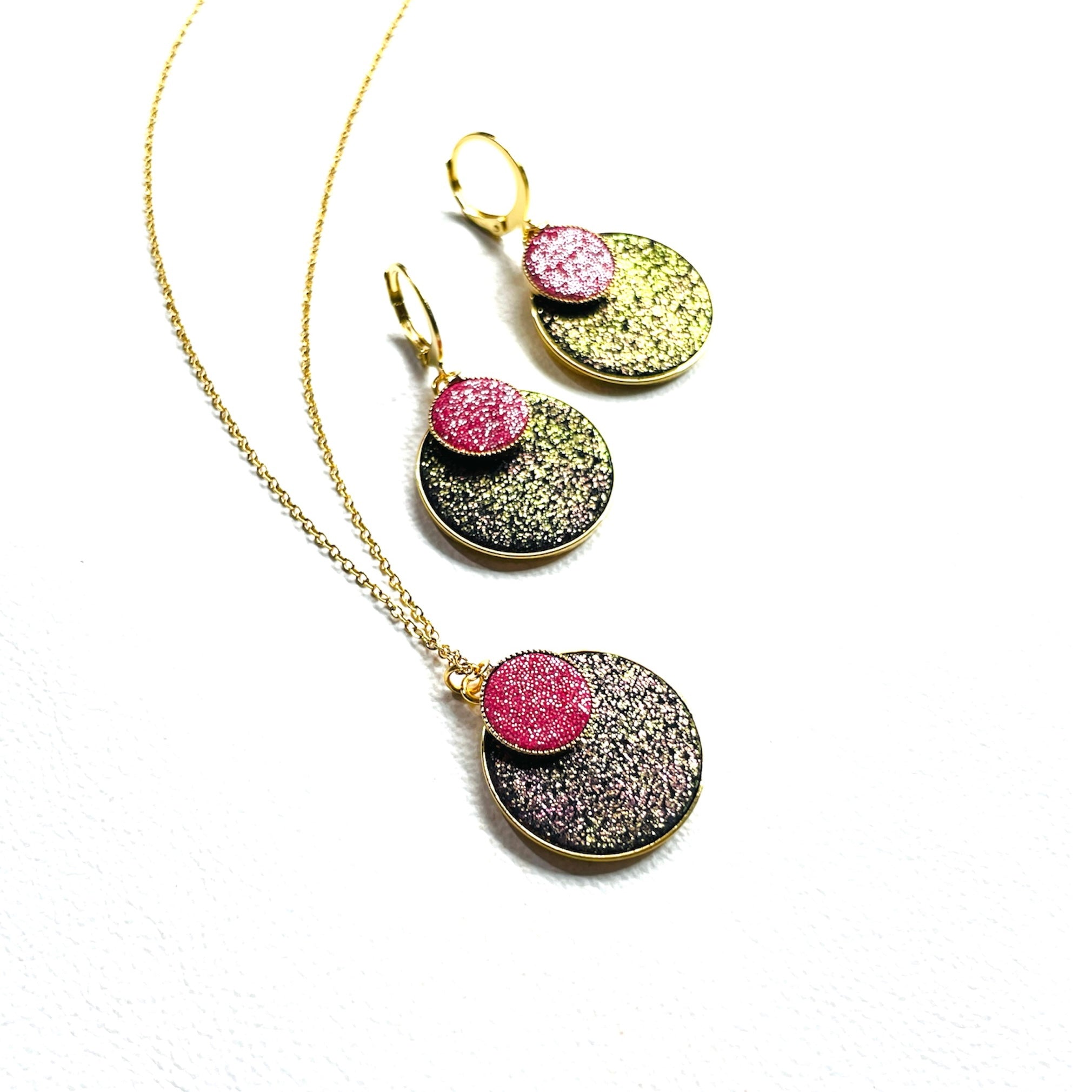 Parure Collier et boucles d'oreilles Bulles pailletées Nune, court doré avec pendentif rond composé de doubles sertis de cuirs noir pailleté irisé et framboise pailletée argent, sur fond blanc