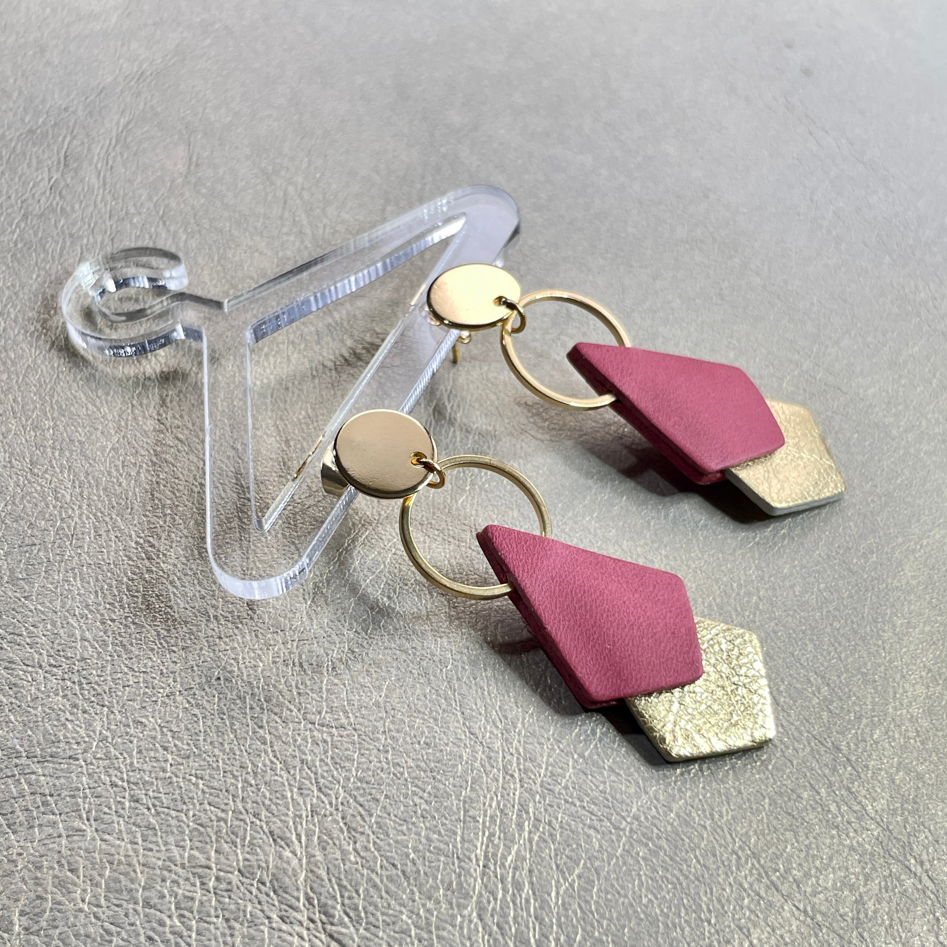 NUNE puces d'oreilles dorées Sagittis, pendentifs en duo de losanges en cuir recyclé vieux rose et doré, sur fond beige doré