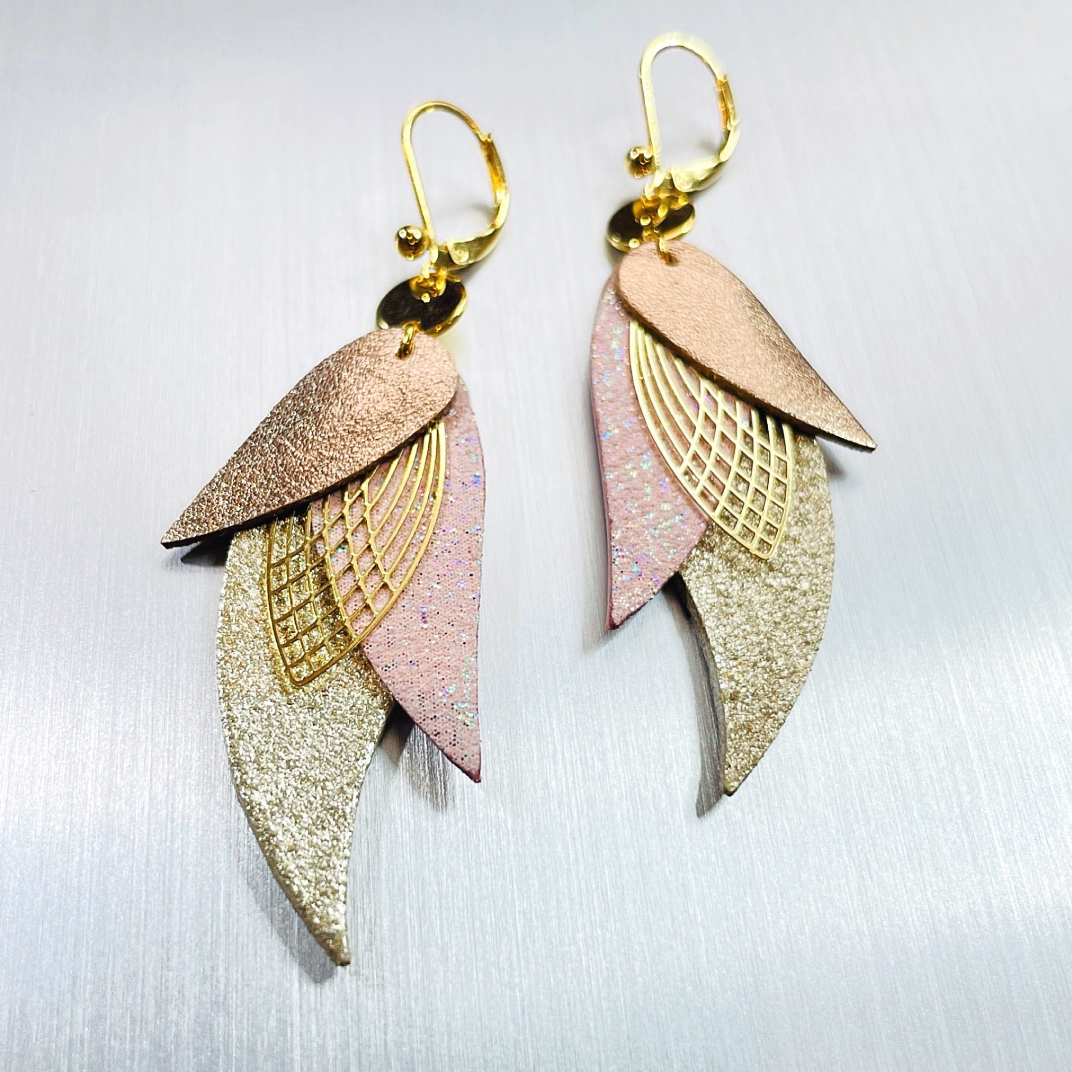boucles d'oreilles dorées Nune modèle Ara en plumes de cuirs cannelle dorée satinée, rose poudré irisé et beige pailleté argent