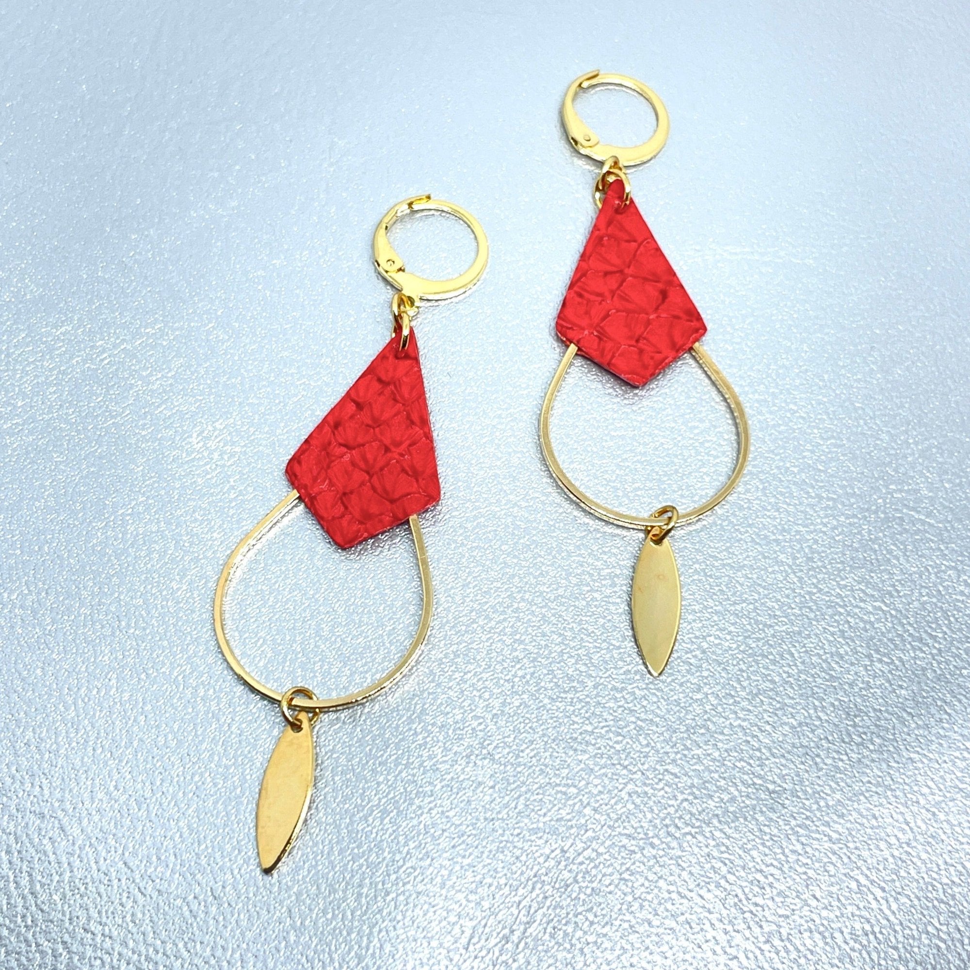 Boucles d'oreilles Gali de Nune, dorées à l'or fin avec triangle de cuir marin, cuir de poisson saumon rouge cardinal, de forme grande goutte, sur fond cuir gris argenté