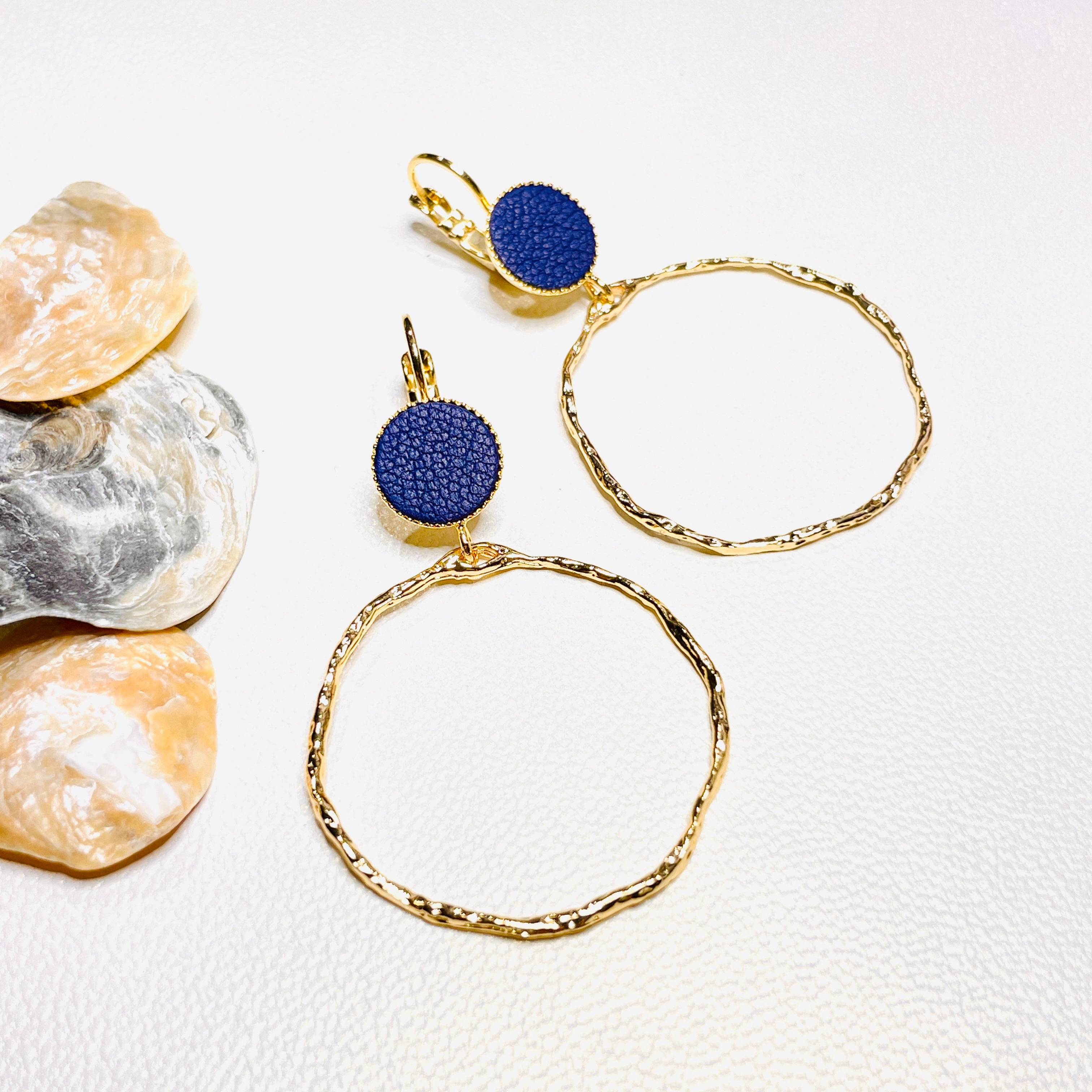 boucles d'oreilles dorées Nune modèle Bali Créoles en cuir marine satiné sur fond blanc