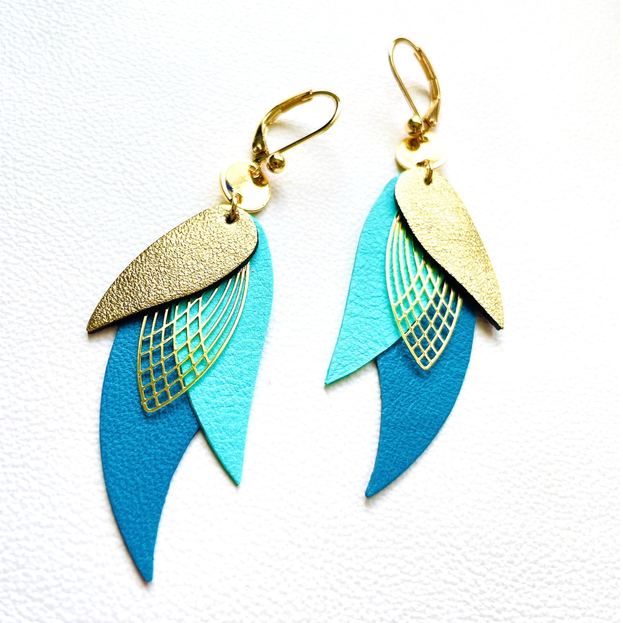 boucles d'oreilles dorées Nune modèle Ara en plumes de cuirs doré satiné, vert menthe satiné et bleu canard satiné sur fond blanc