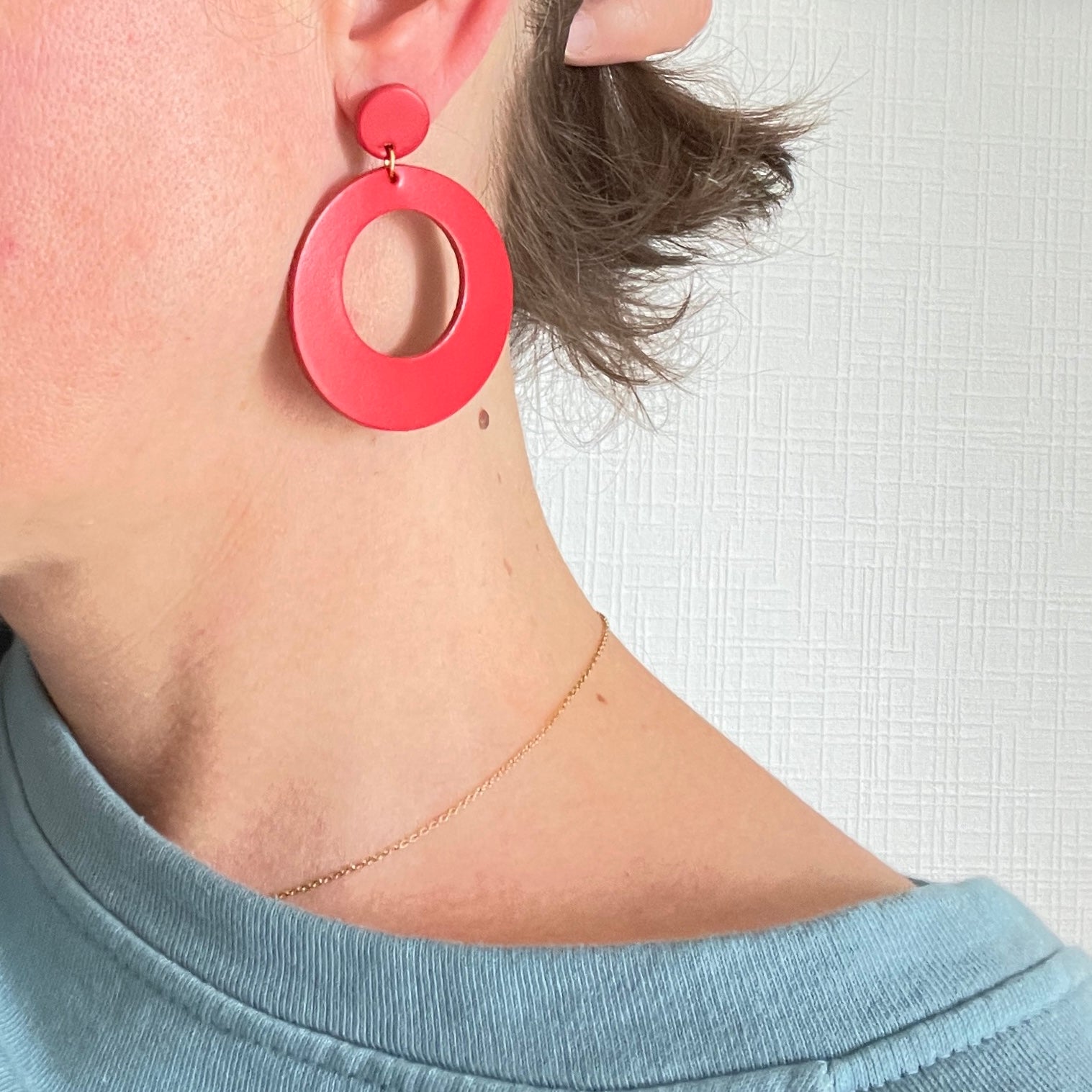 Boucle d'oreille créole tout cuir style vintage Nune modèle Lola en cuir upcyclé rouge, portée à l'oreille