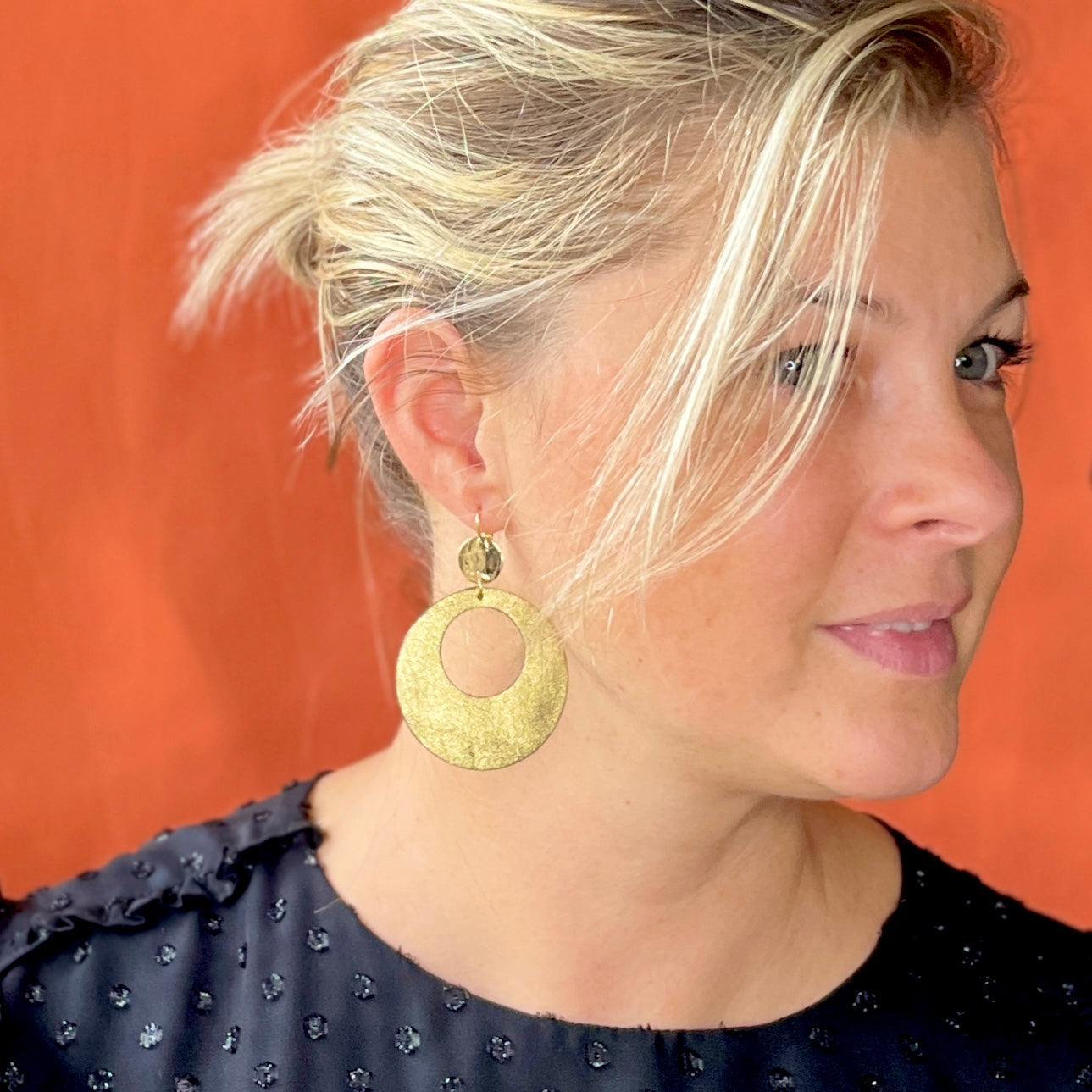 Nune grande boucle d'oreilles créole Zoa au style vintage en cuir doré satiné, montée sur dormeuse martelée dorée à l'or fin, portée à l'oreille