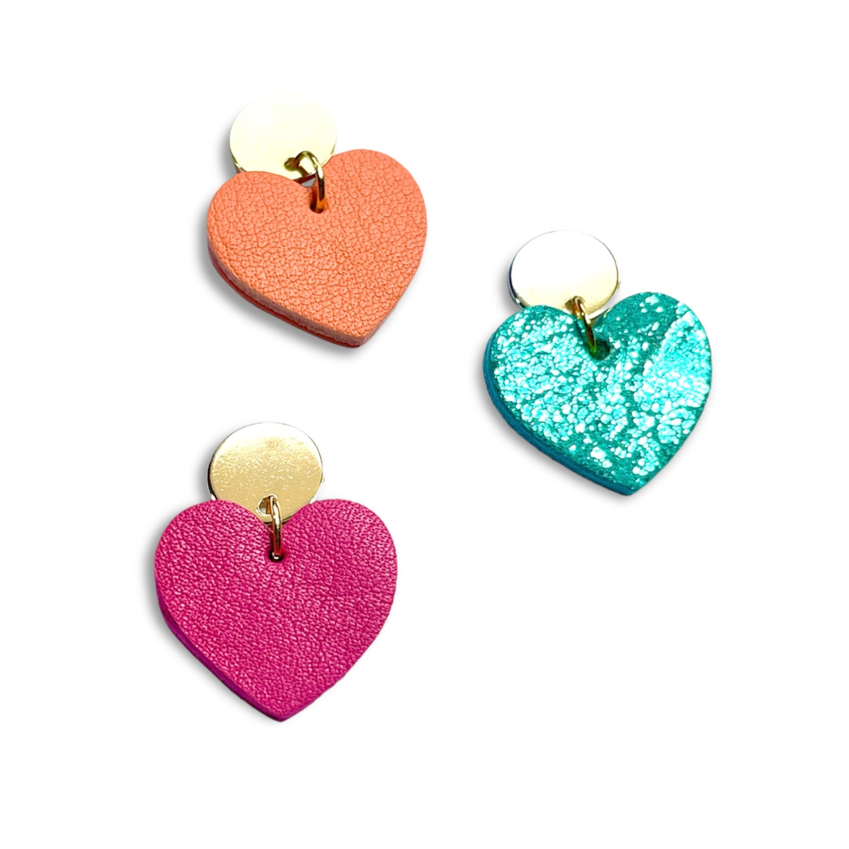 NUNE puces d'oreilles dorées Mims avec pendentifs cœurs en cuirs rose fuschia, vert émeraude brillant et saumon clair recyclés, vues de haut