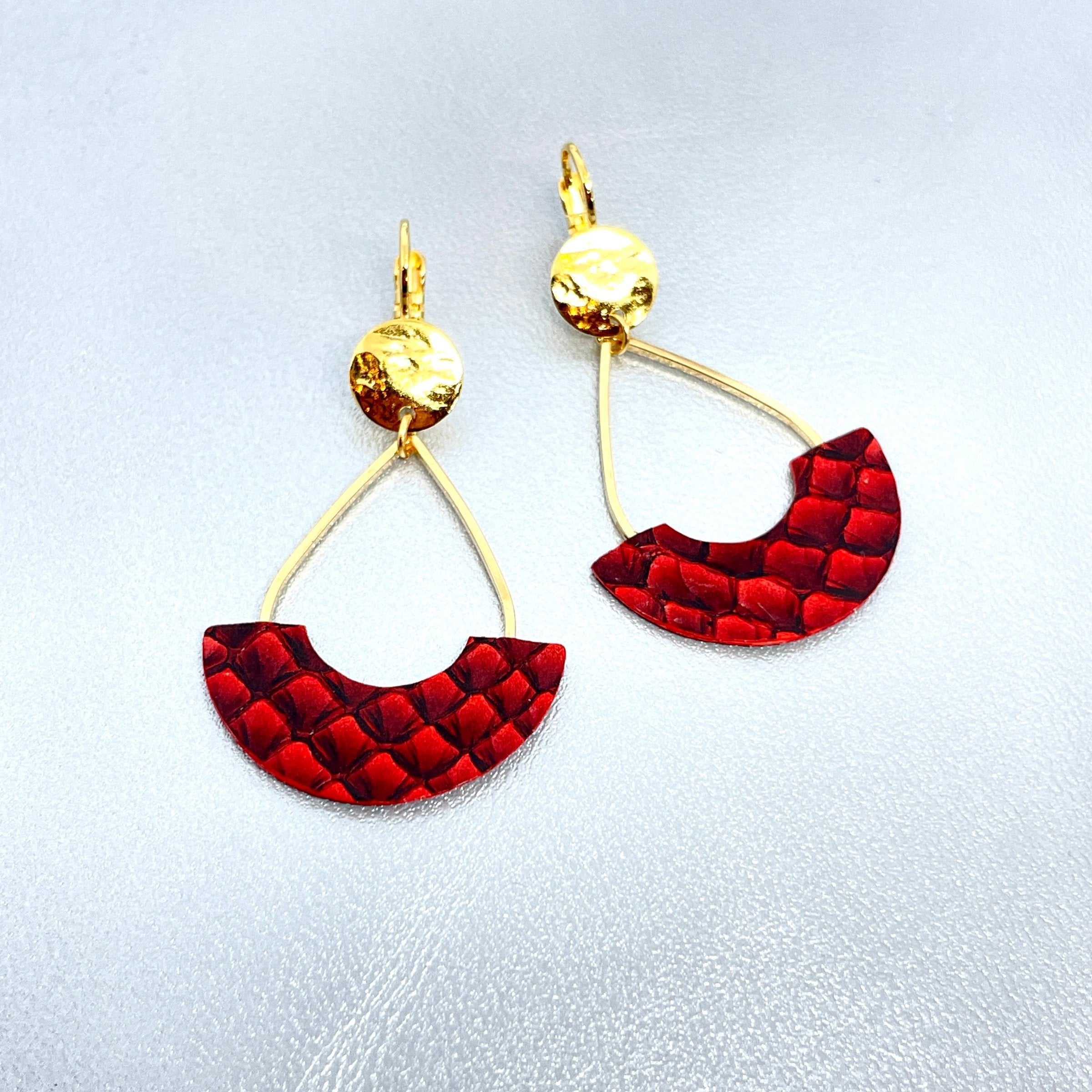 Boucles d'oreilles Anoush de Nune, dorées à l'or fin avec cuir marin, cuir de poisson saumon rouge carmin écaille, en forme de demi-lune, sur fond cuir gris argenté